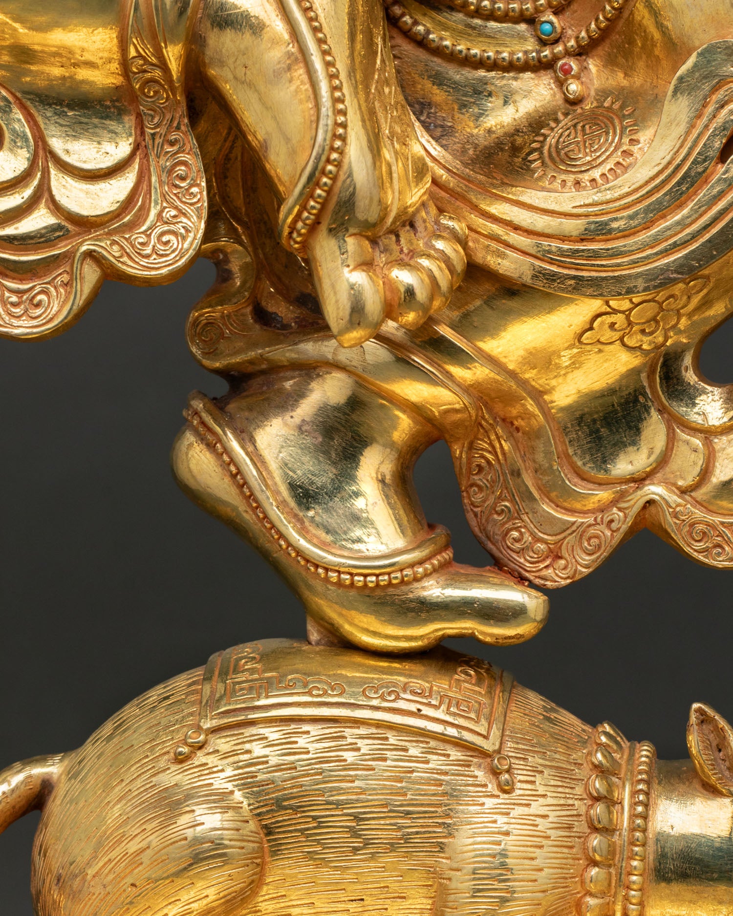 Ganesh statue hand detail holding sword near sacred mouse vehicle
