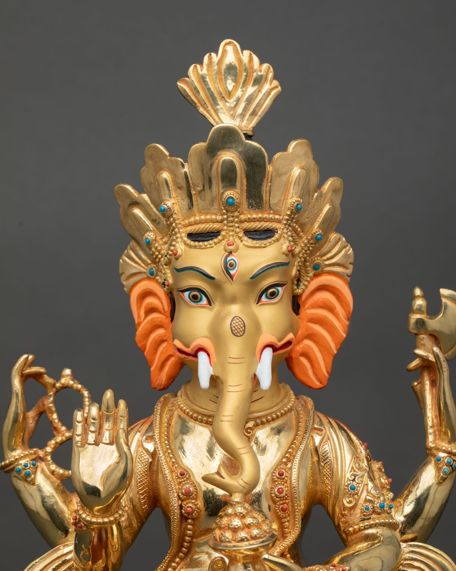 Ganesha statue close up view elephant headed deity sacred details semi precious stones gold gilded Himalayan art