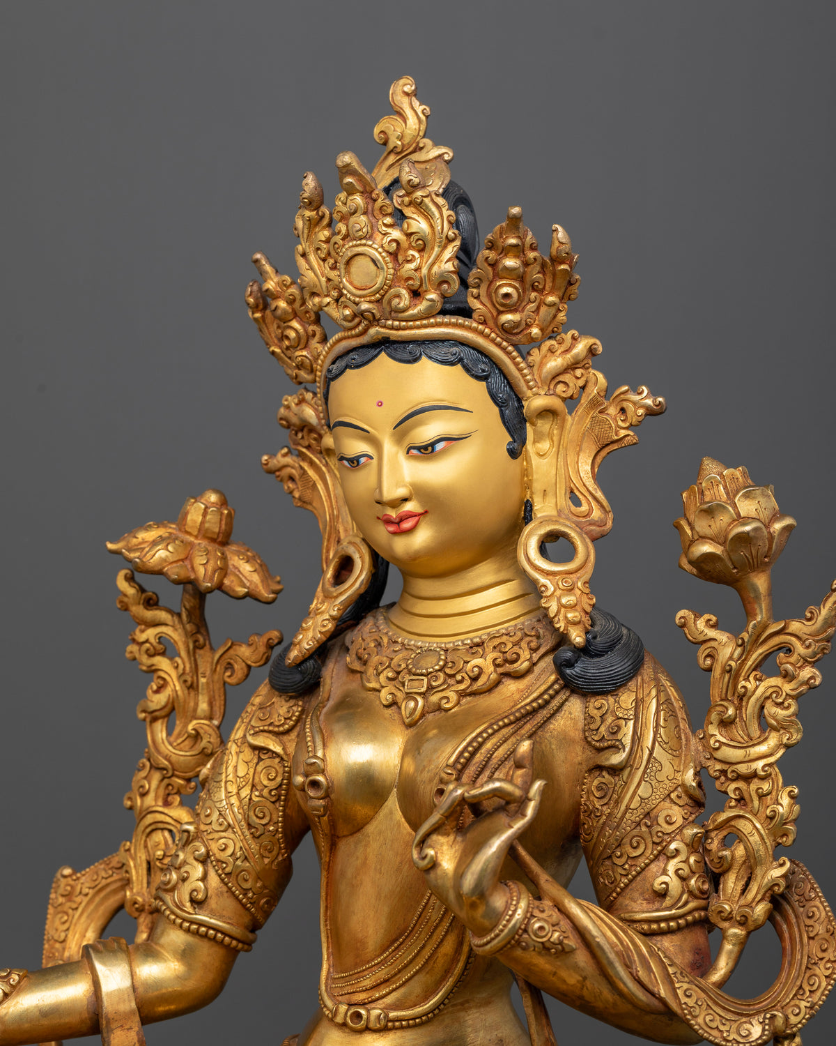 Gold gilded Green Tara Buddhist statue with elaborate earrings necklaces and garment.