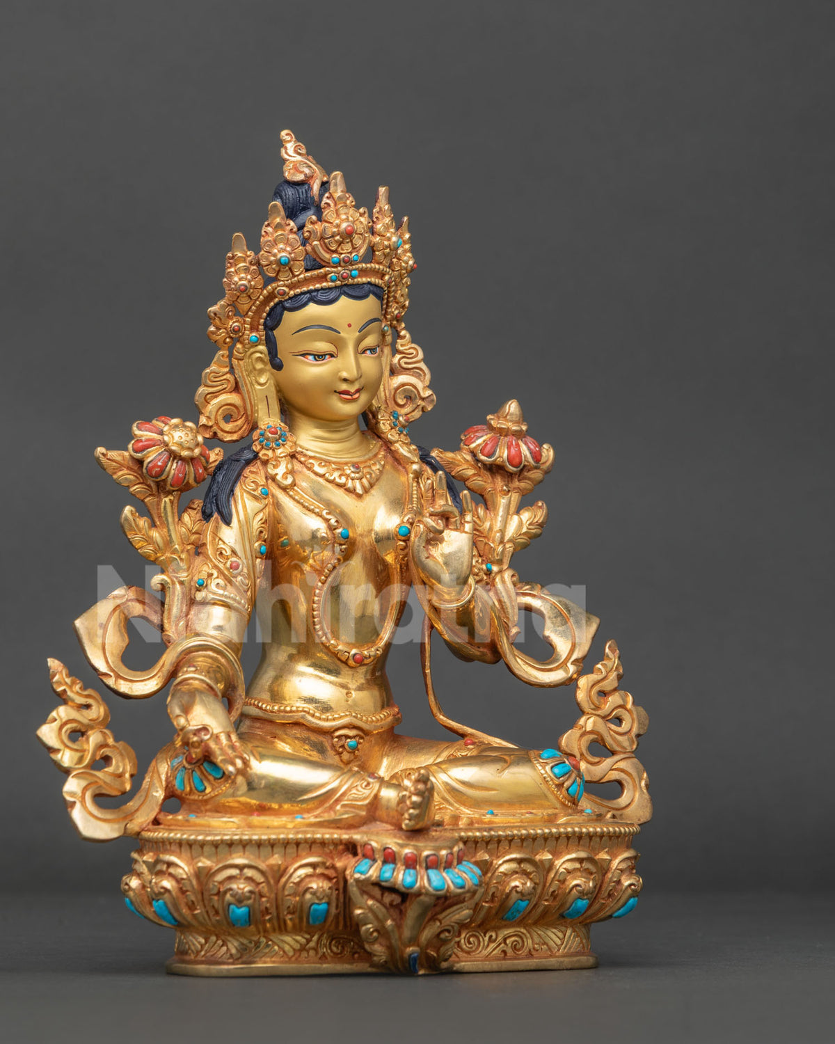 Gold fire gilded Green Tara statue side view with detailed earrings necklaces garment and lotus base.