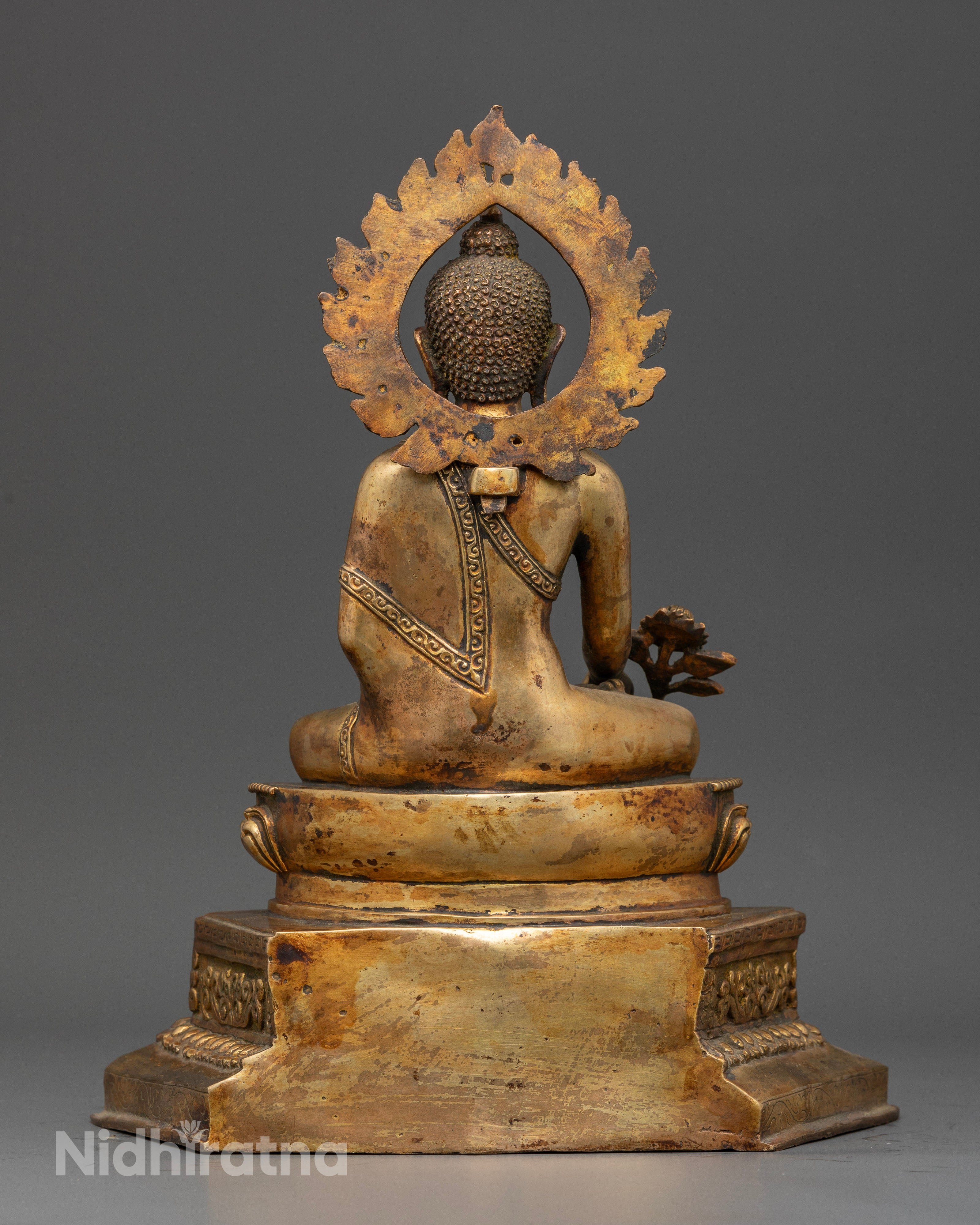 Gold fire gilded medicine buddha statue with antique finish and halo.