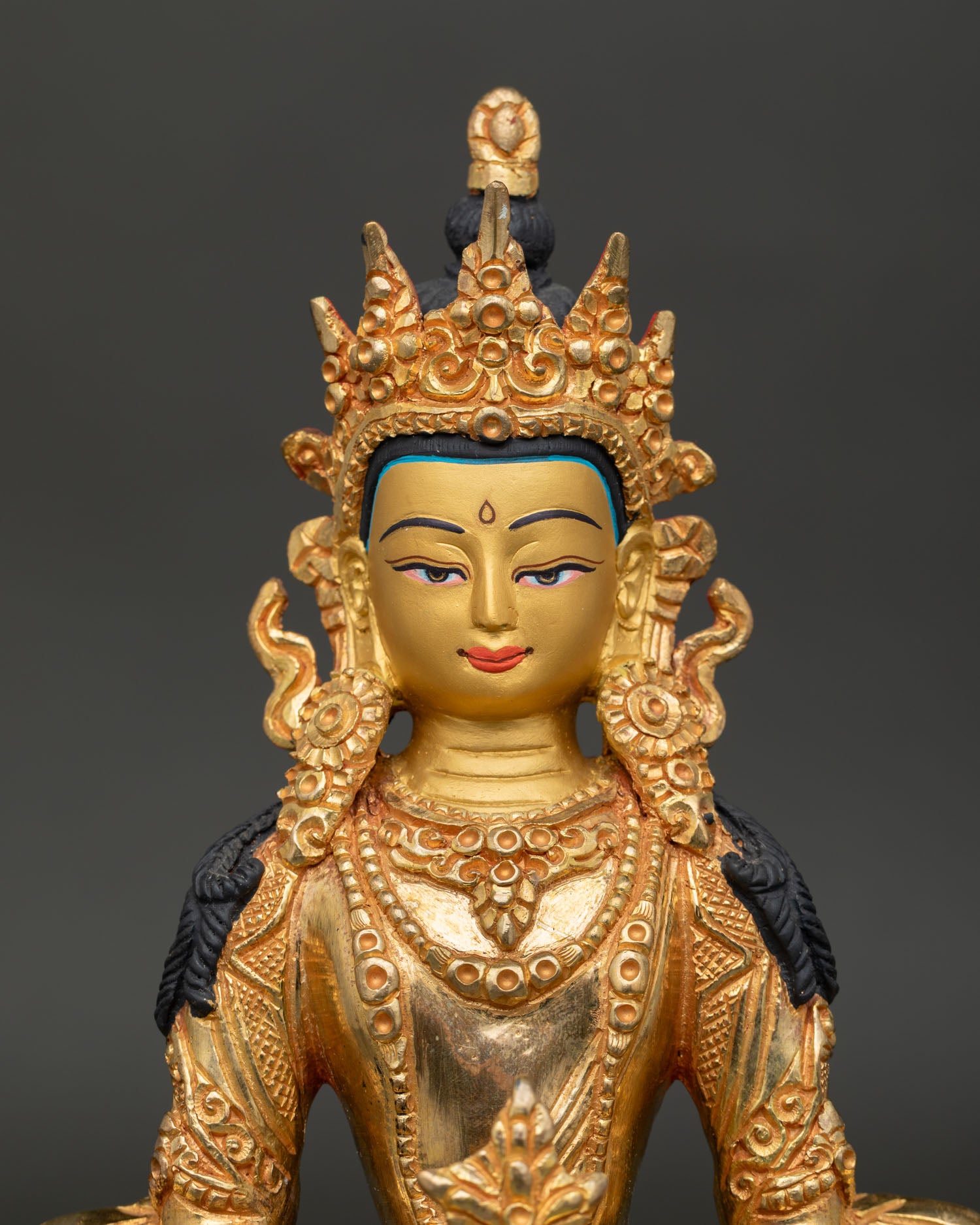 Gold gilded Amitayus Buddha showing painted face and traditional Nepalese craftsmanship.