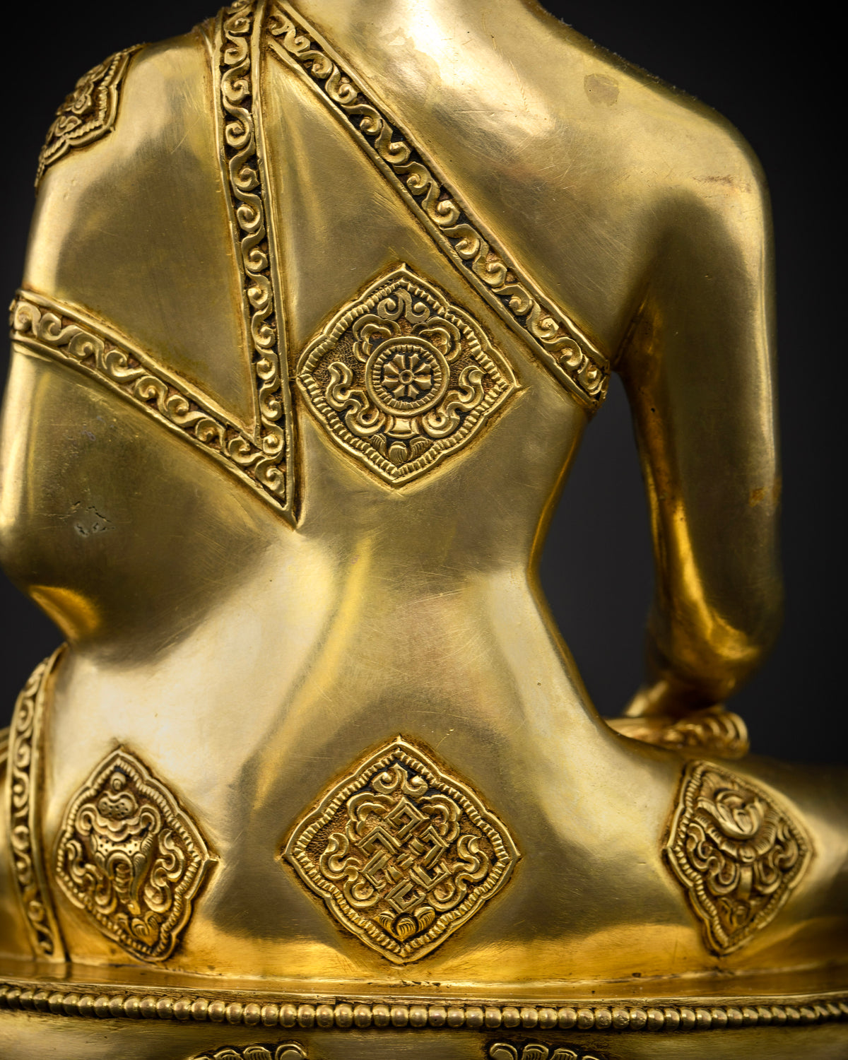 Gold-gilded Shakyamuni Buddha sculpture with a finely detailed gold-painted face and a monastic robe engraved with the Eight Auspicious Symbols.