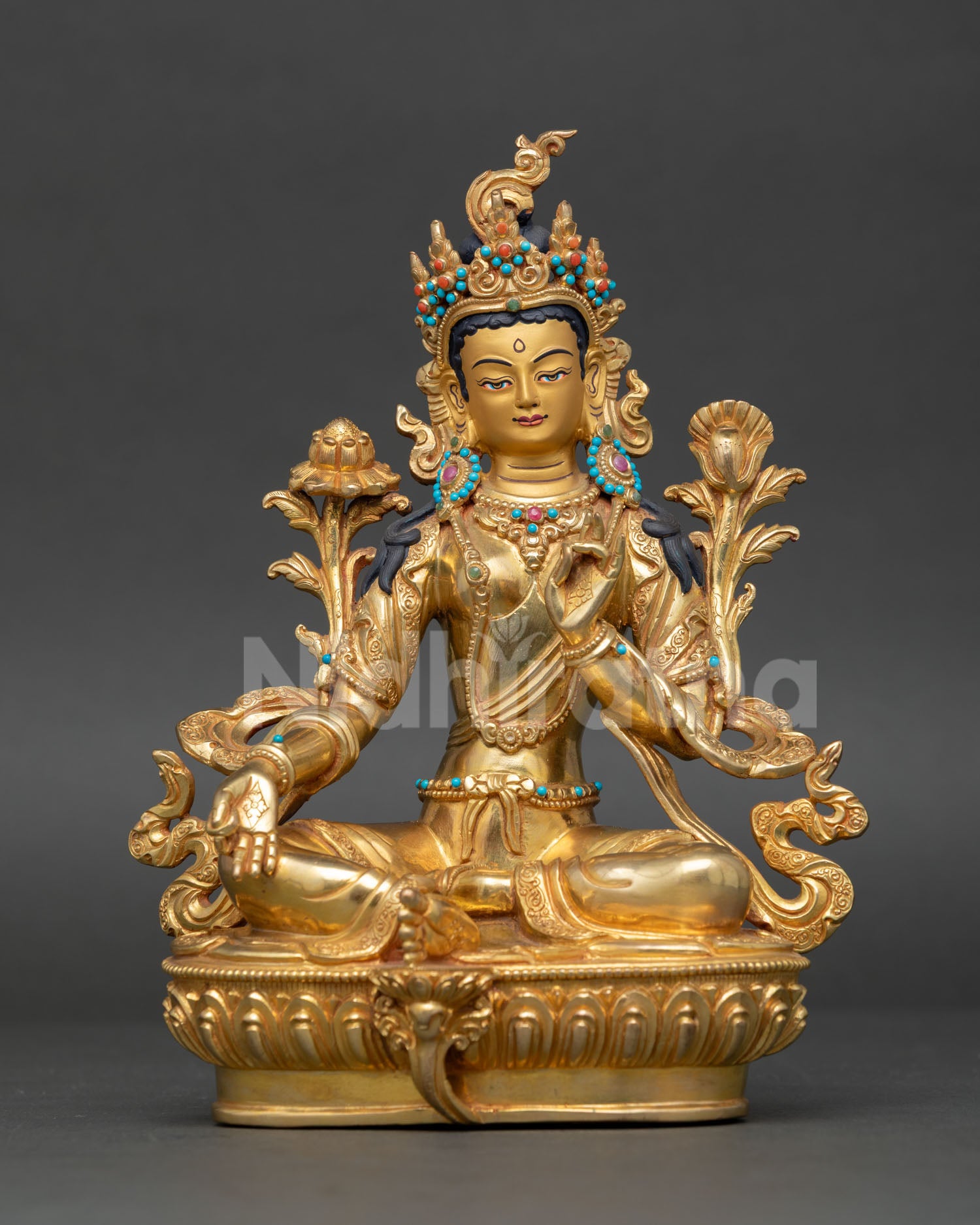 Green Tara Buddhist goddess sculpture seated on lotus throne with extended leg posture and semi precious stone adornments.