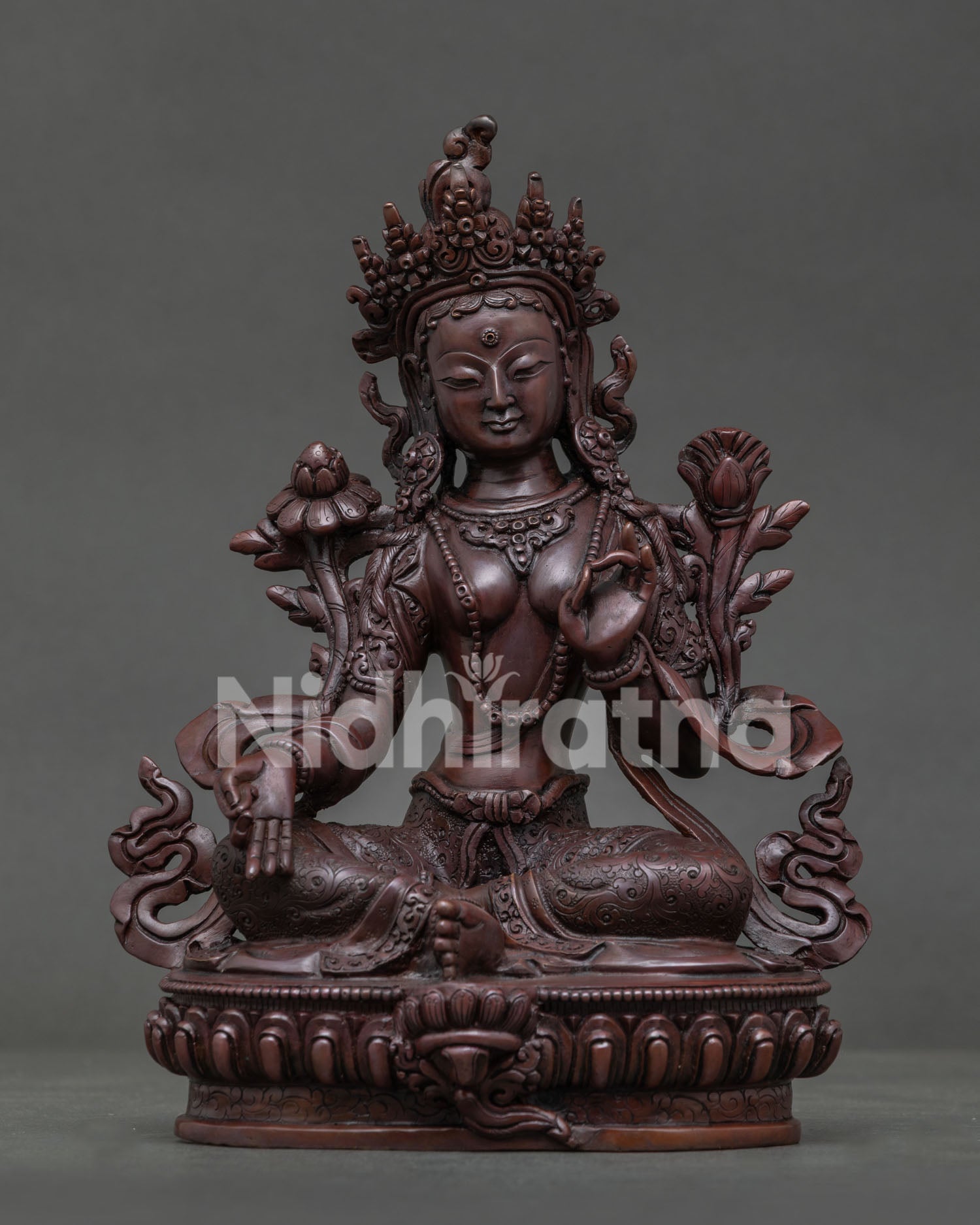 Green Tara Buddhist statue seated on lotus throne with carved silk garments.