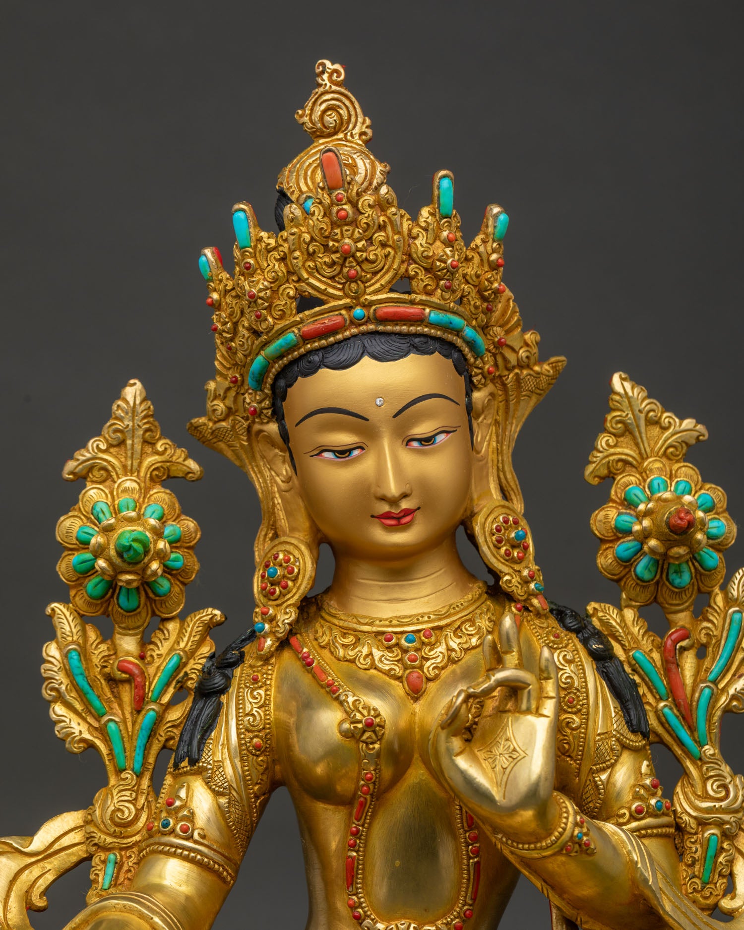Close up of Green Tara copper statue Thailand showing gold gilding and jeweled crown detail