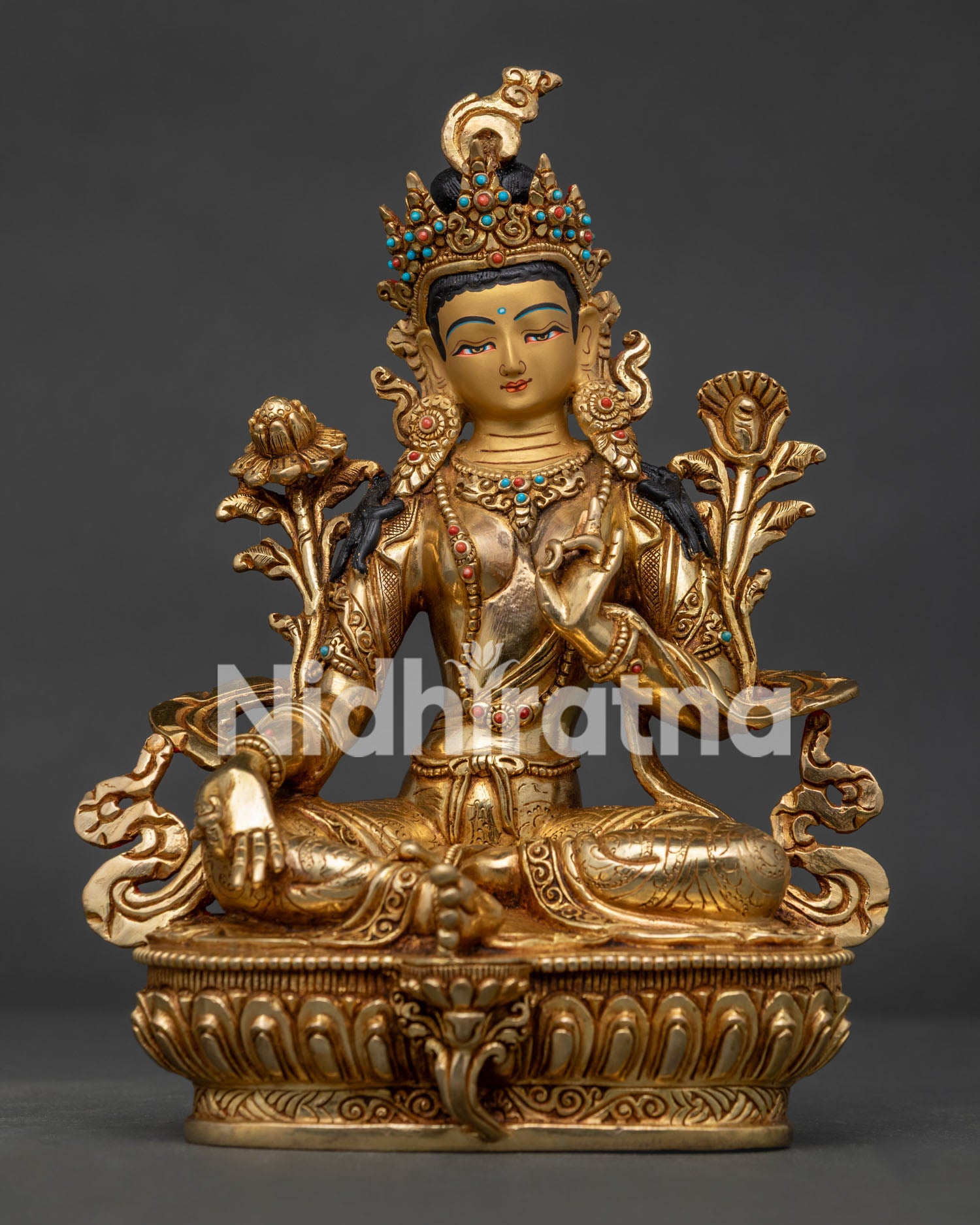 Green Tara copper statue seated on lotus throne with Utpala flower.