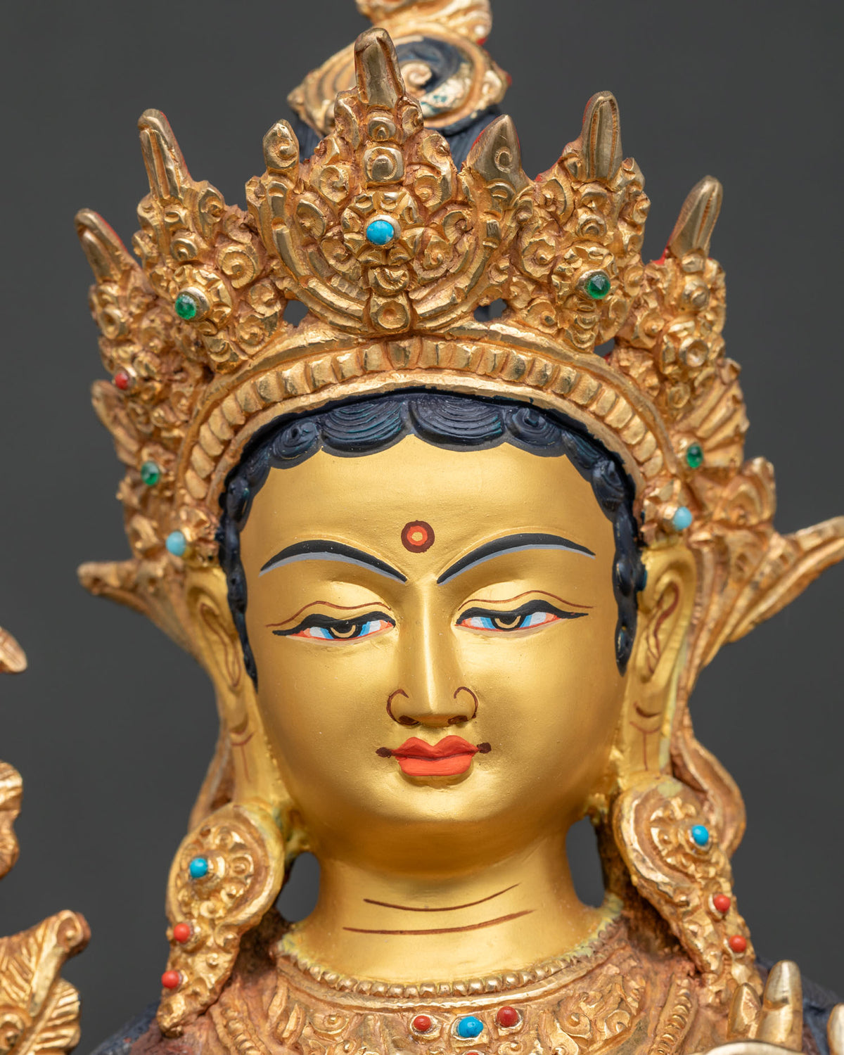 Green Tara face close up 24K gold painted serene expression.