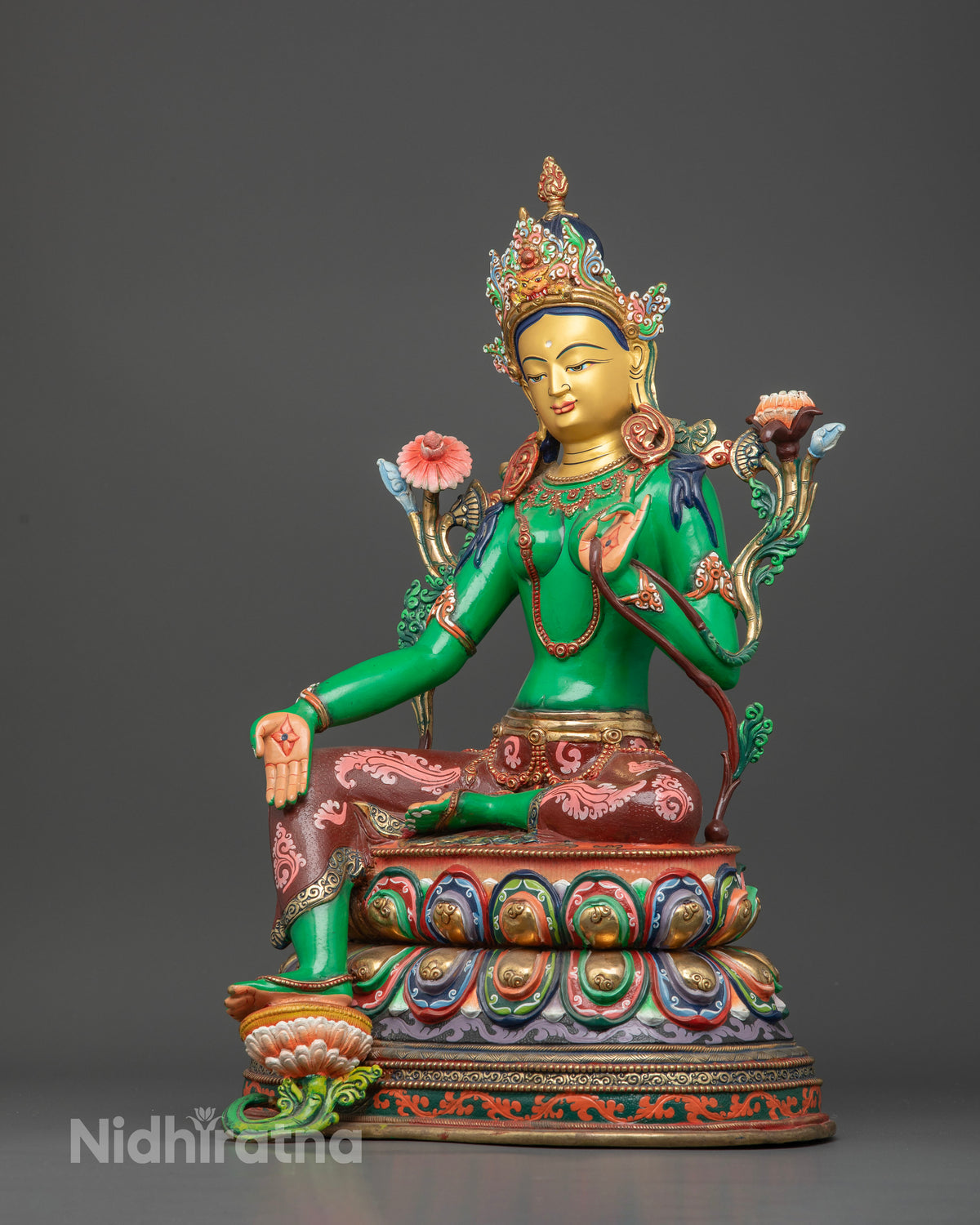 Green Tara holding blooming utpala lotus with floral motif silk garment.