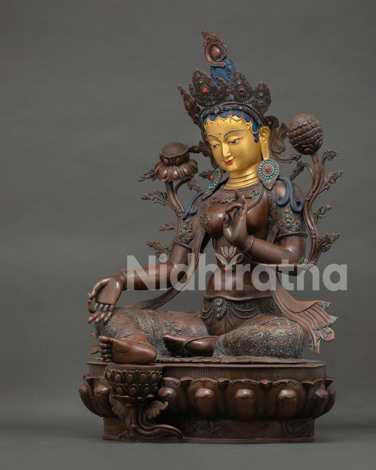 Green Tara left side view—handcrafted copper figurine holding utpala lotus, enlightenment symbol