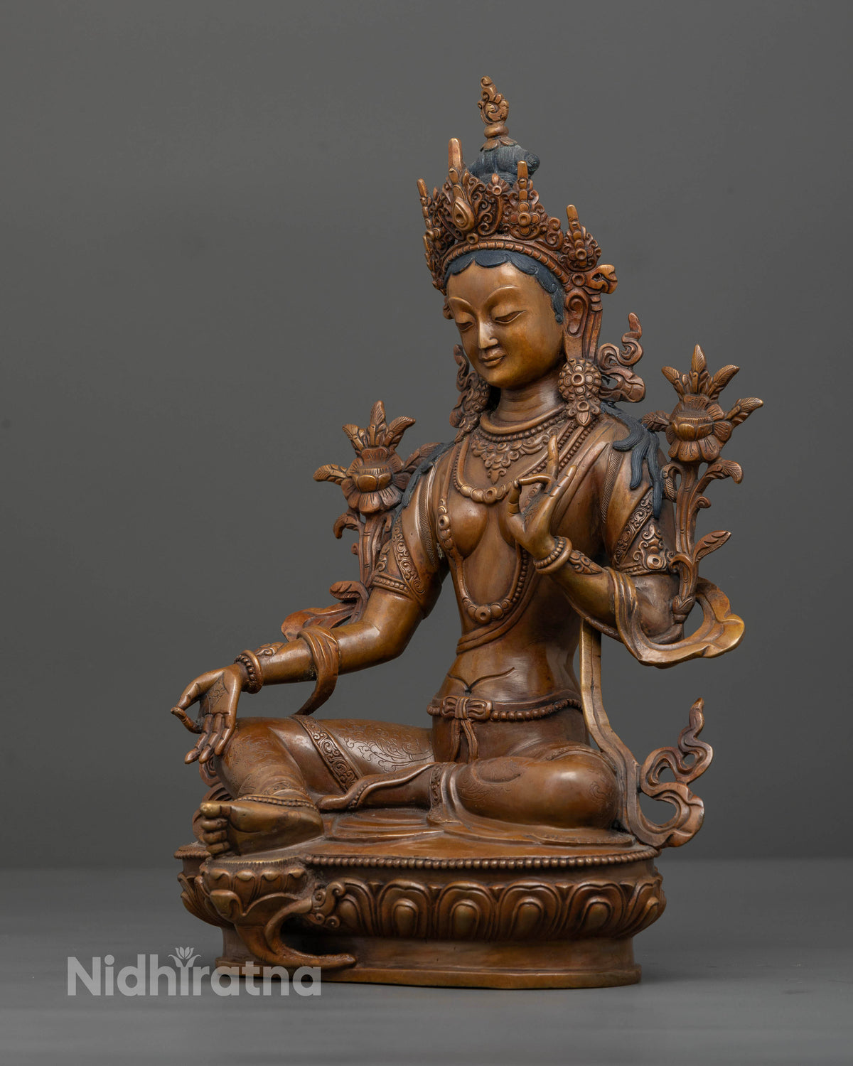 Green Tara seated gracefully on lotus pedestal with extended right leg