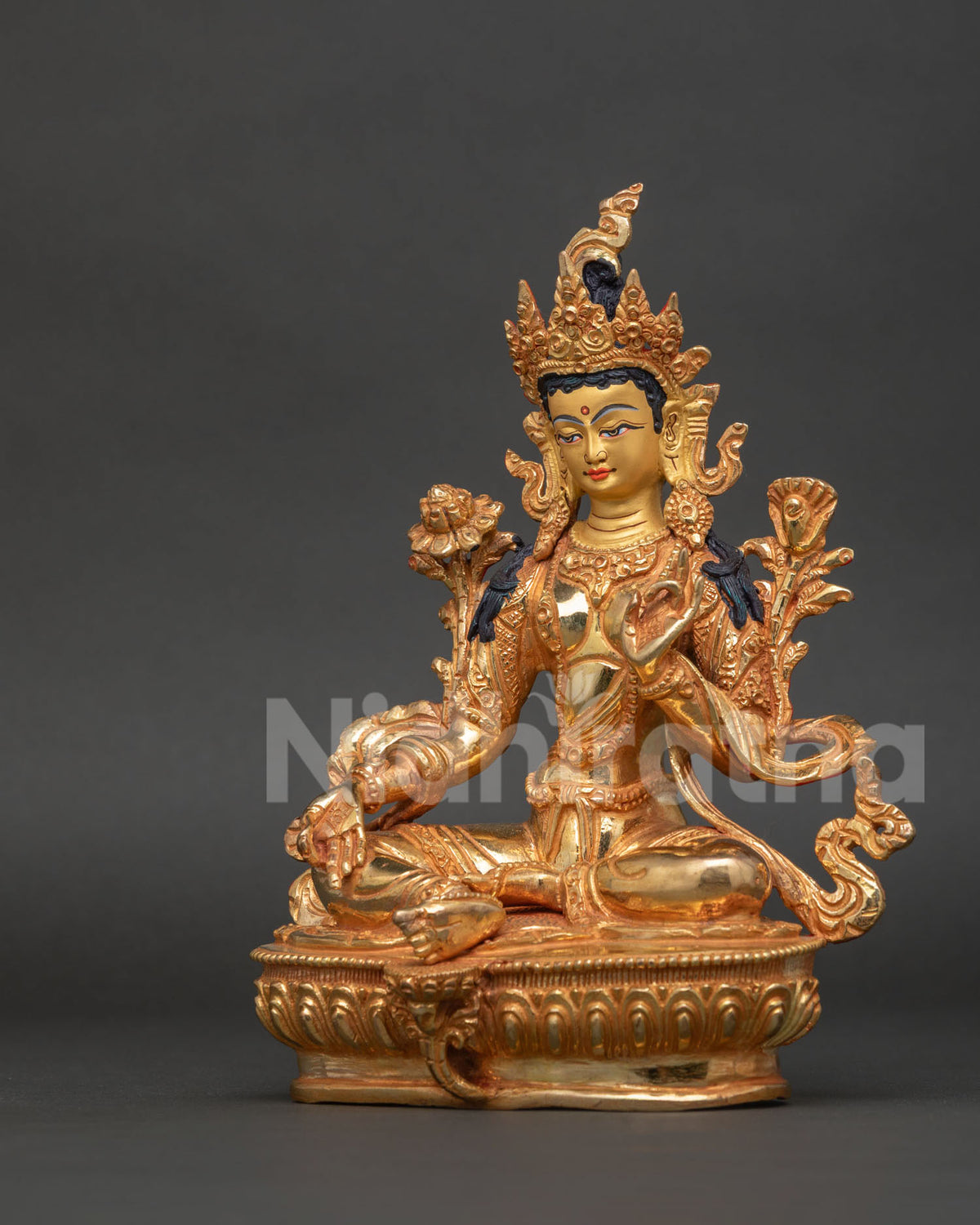 Green tara seated in lalitasana on a detailed lotus pedestal holding sacred utpala flower.