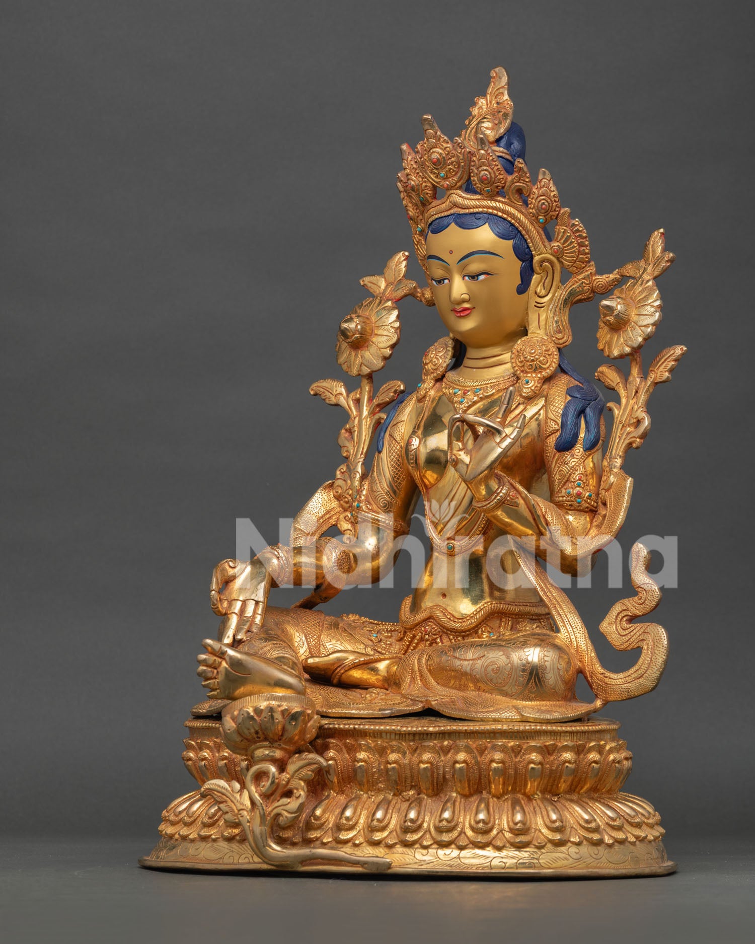 Green Tara seated on double lotus pedestal with right leg extended on lotus symbolizing compassion