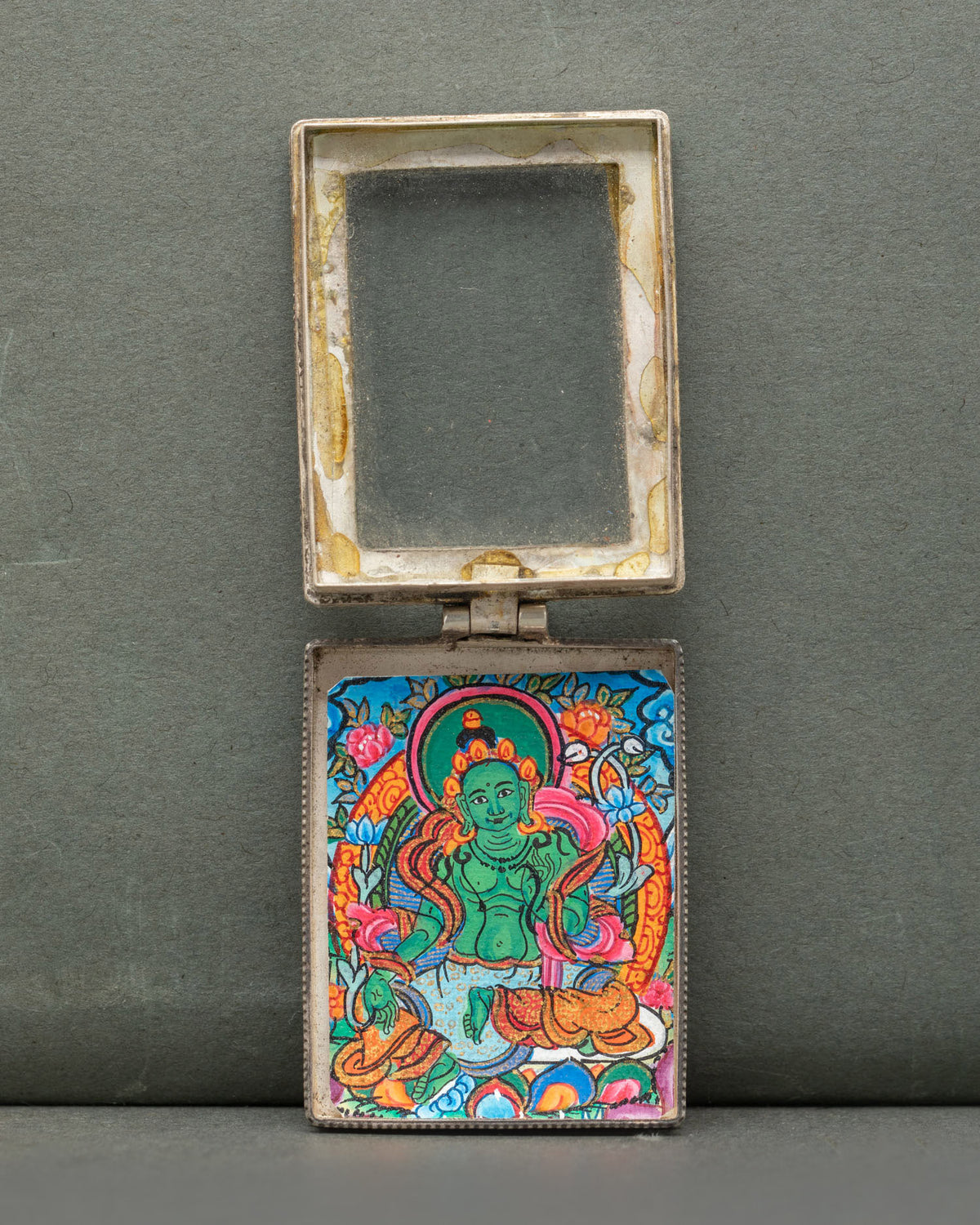 Green Tara silver Buddhist locket featuring a miniature hand-painted Green Tara thangka on cotton canvas with acrylic paints.
