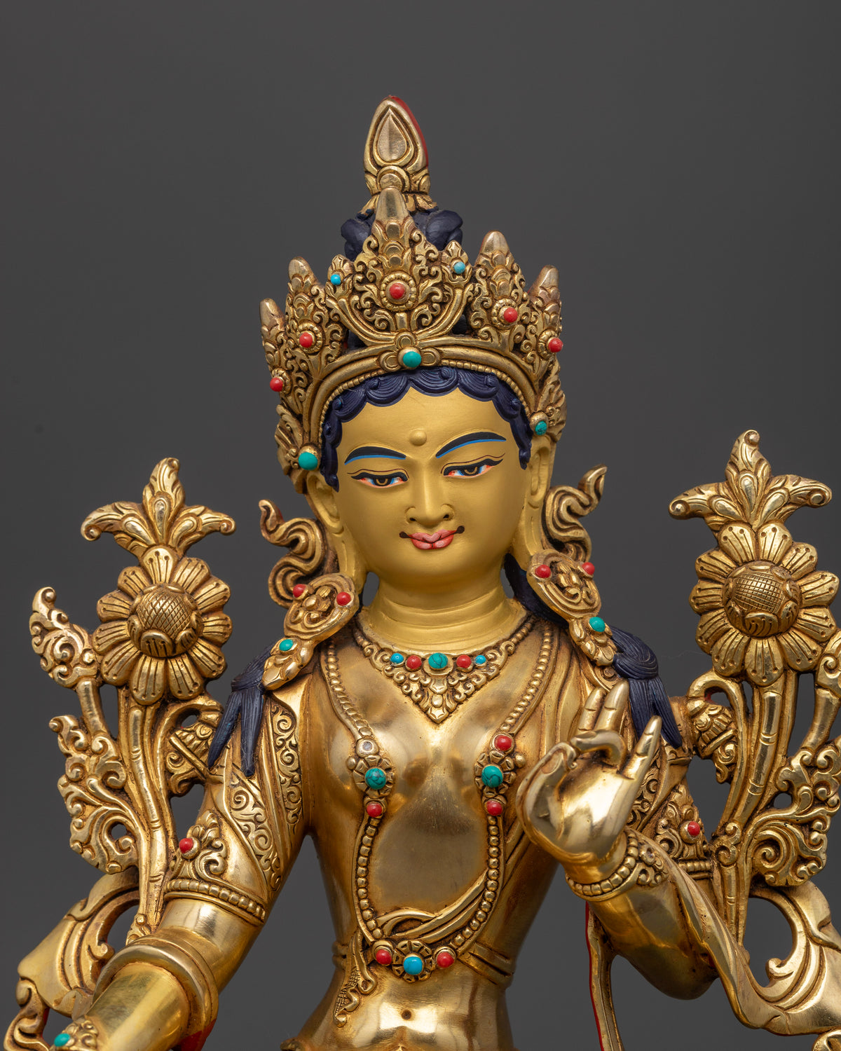 Green Tara statue close up 24K gold painted face semi precious stones Newari craftsmanship.