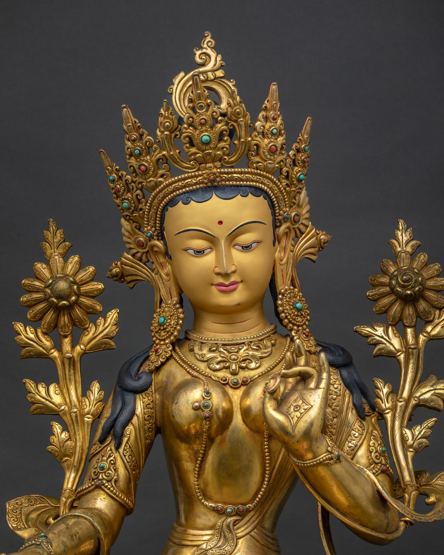Green Tara Statue close up, handcrafted details of gold gilded Buddhist sculpture