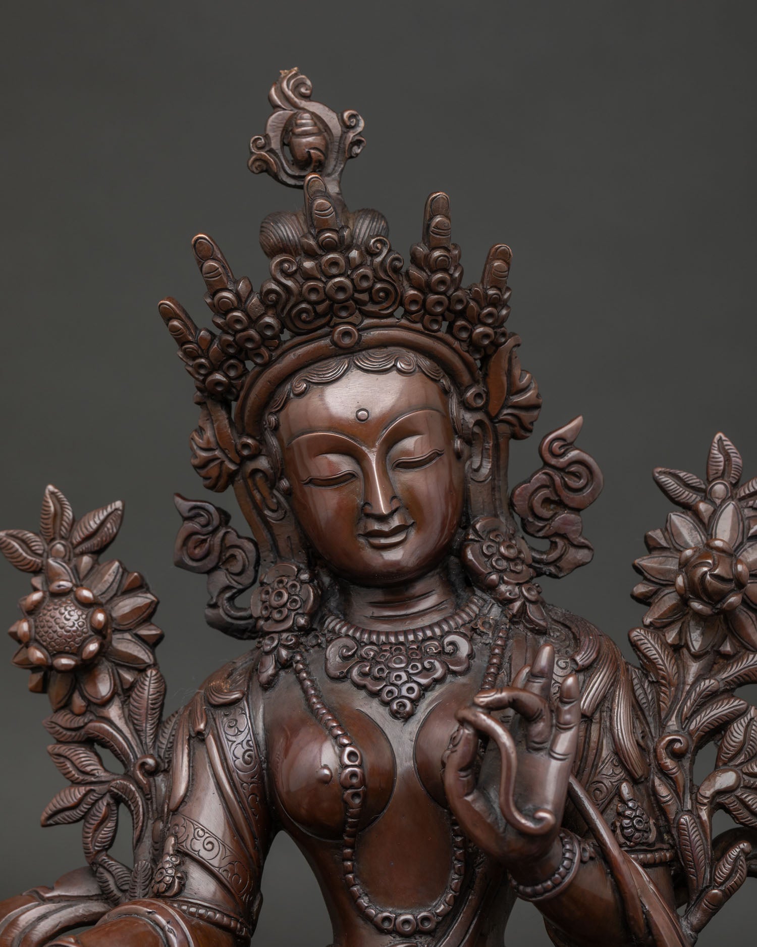 Green Tara Statue close up with jeweled crown and hand carved silk garment.