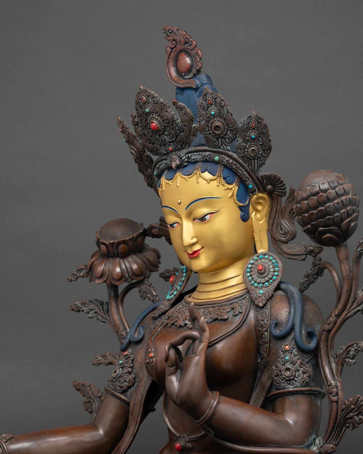 Green Tara statue face—24K gold-painted serene expression with ornate ritual headdress detail