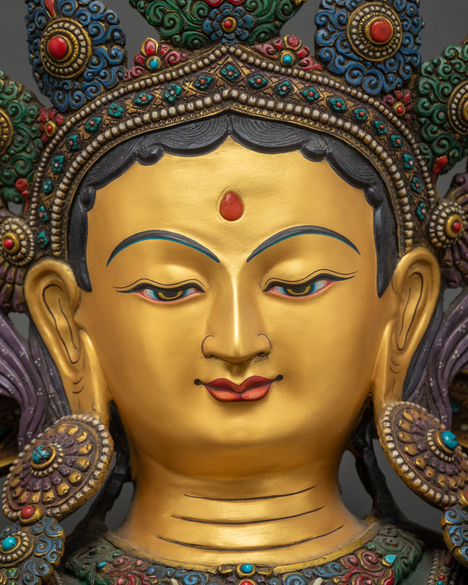 Green Tara Statue face close up, gold painted serene expression detai