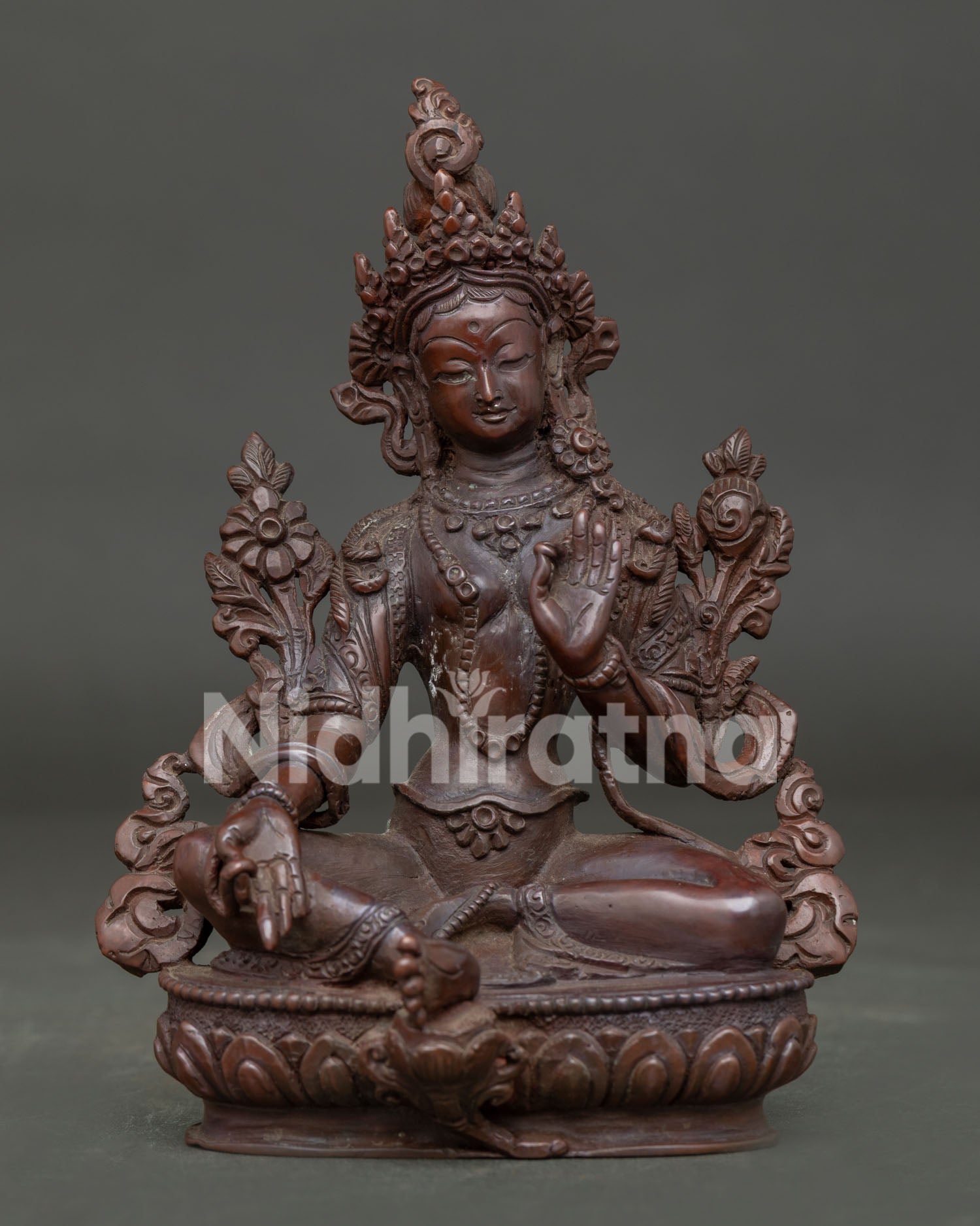 Green Tara Statue handcrafted in Nepal with oxidized copper finish seated on lotus throne.