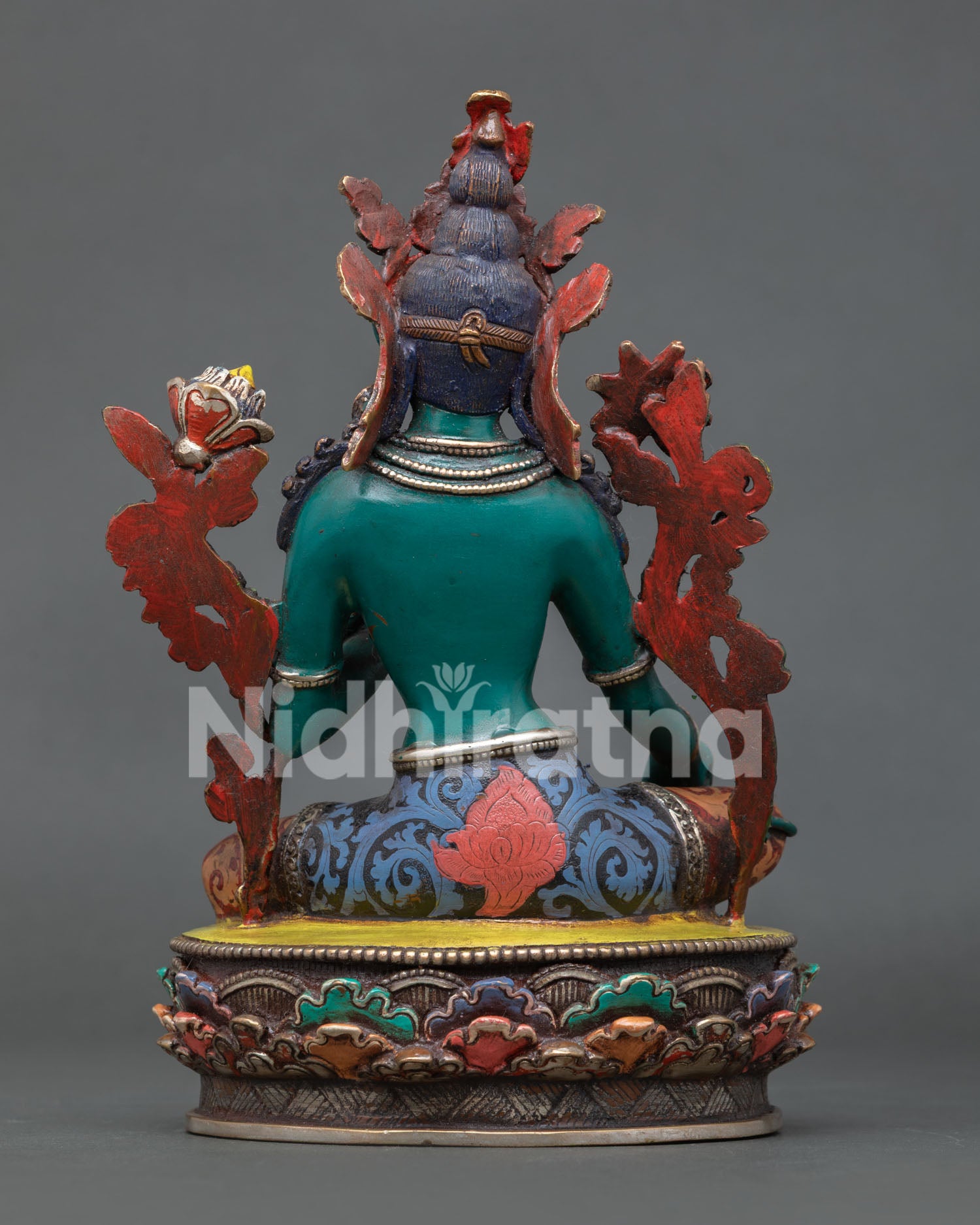 Green Tara statue in Lalitasana posture holding a blue lotus flower with sacred symbolic details.