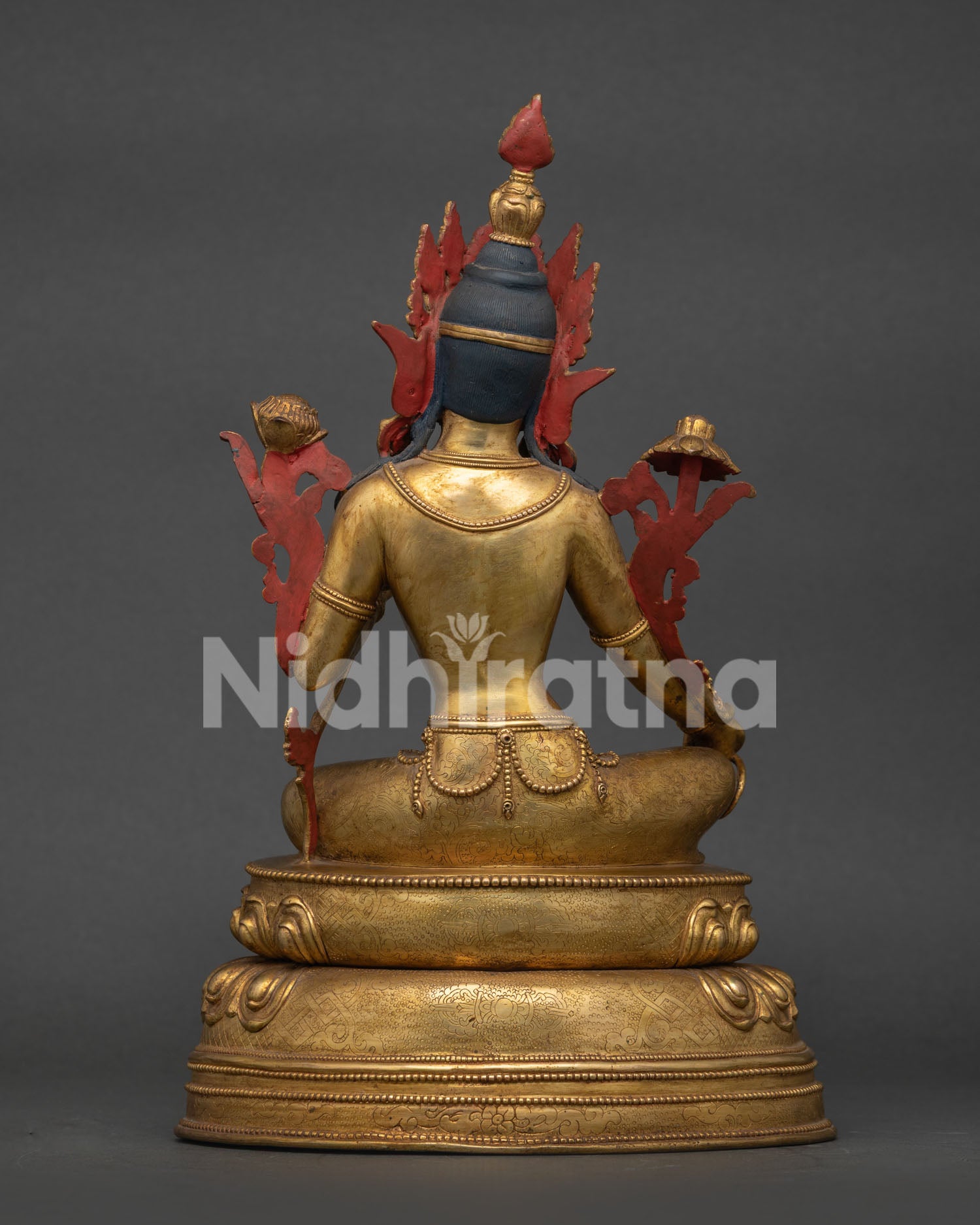 Green tara statue seated in lalitasana posture with ornate lotus pedestal.
