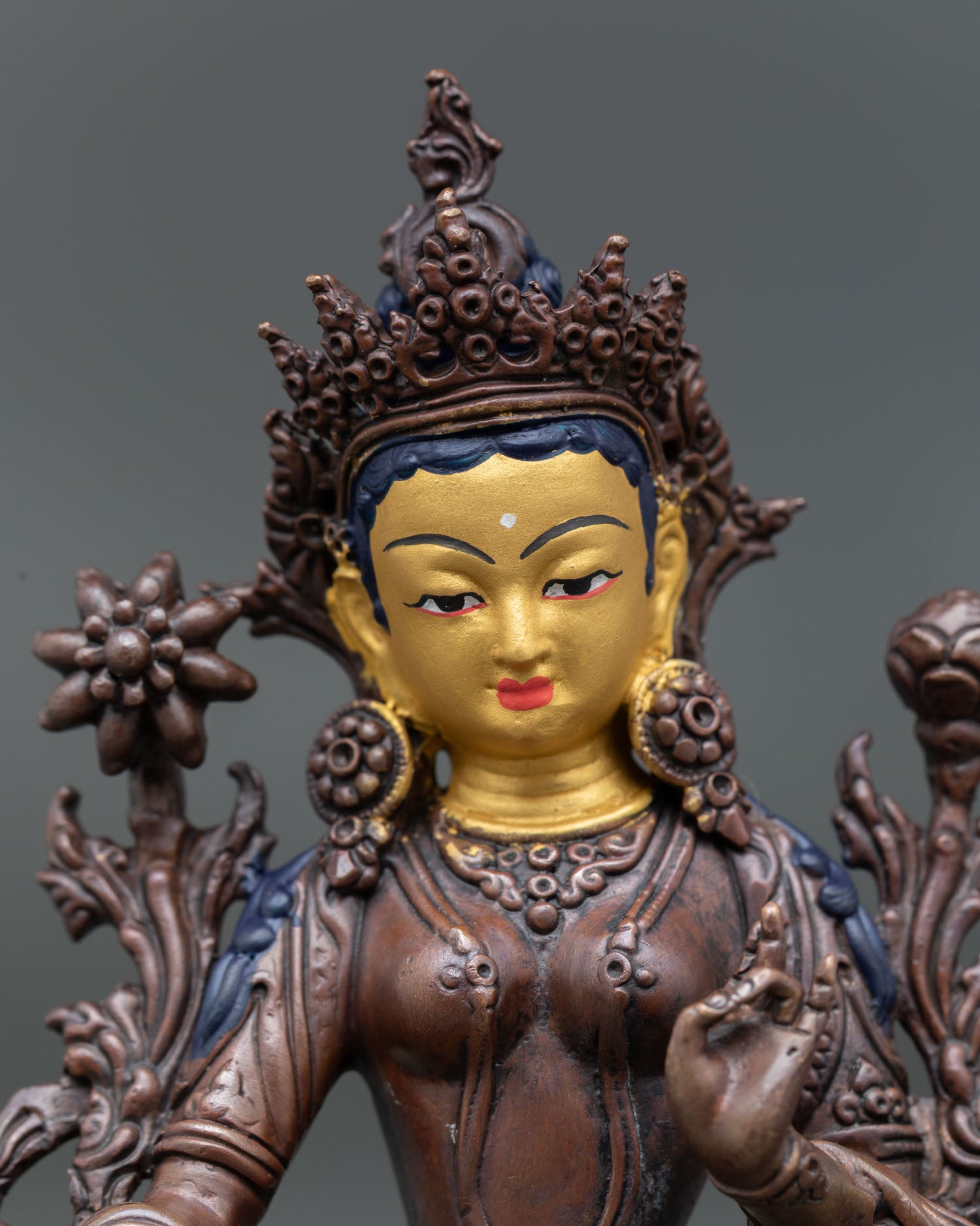 Green Tara Statue showing serene gold painted face, intricate details, and compassionate expression.