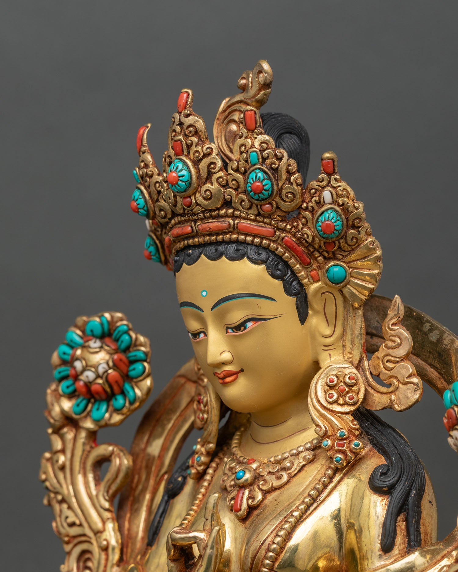 Side close up of Green Tara statue highlighting hand carved floral lower robes