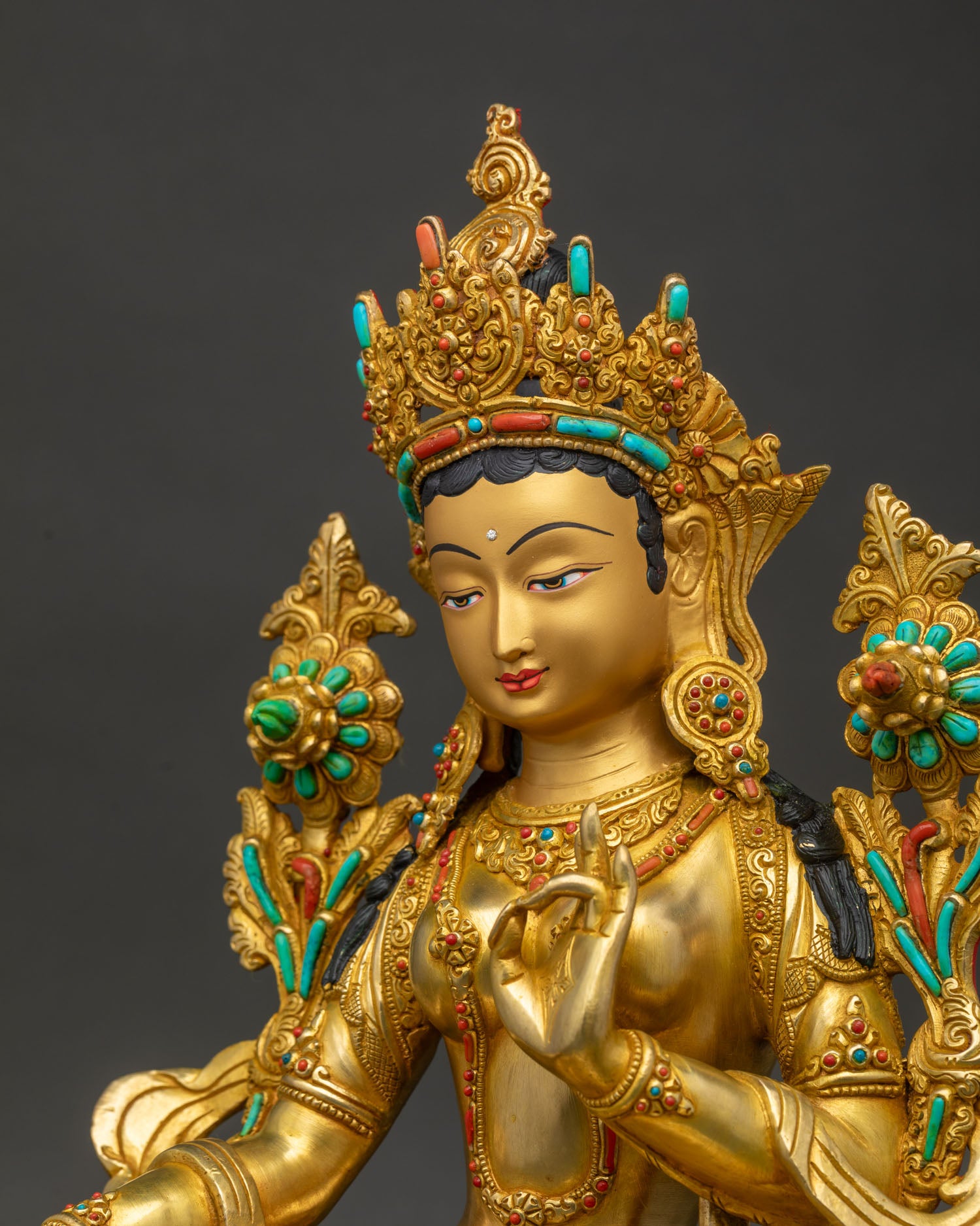Side close up of Green Tara statue Vietnam showing turquoise inlay and lotus mudra detail