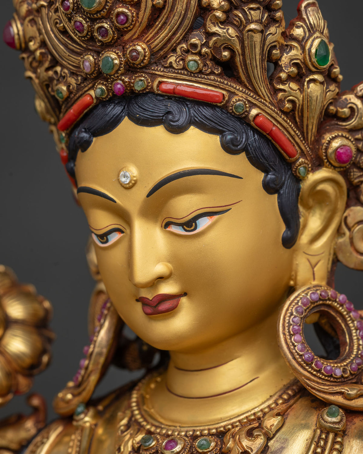 Green Tara Statue side profile face close-up, gold-painted compassionate expression