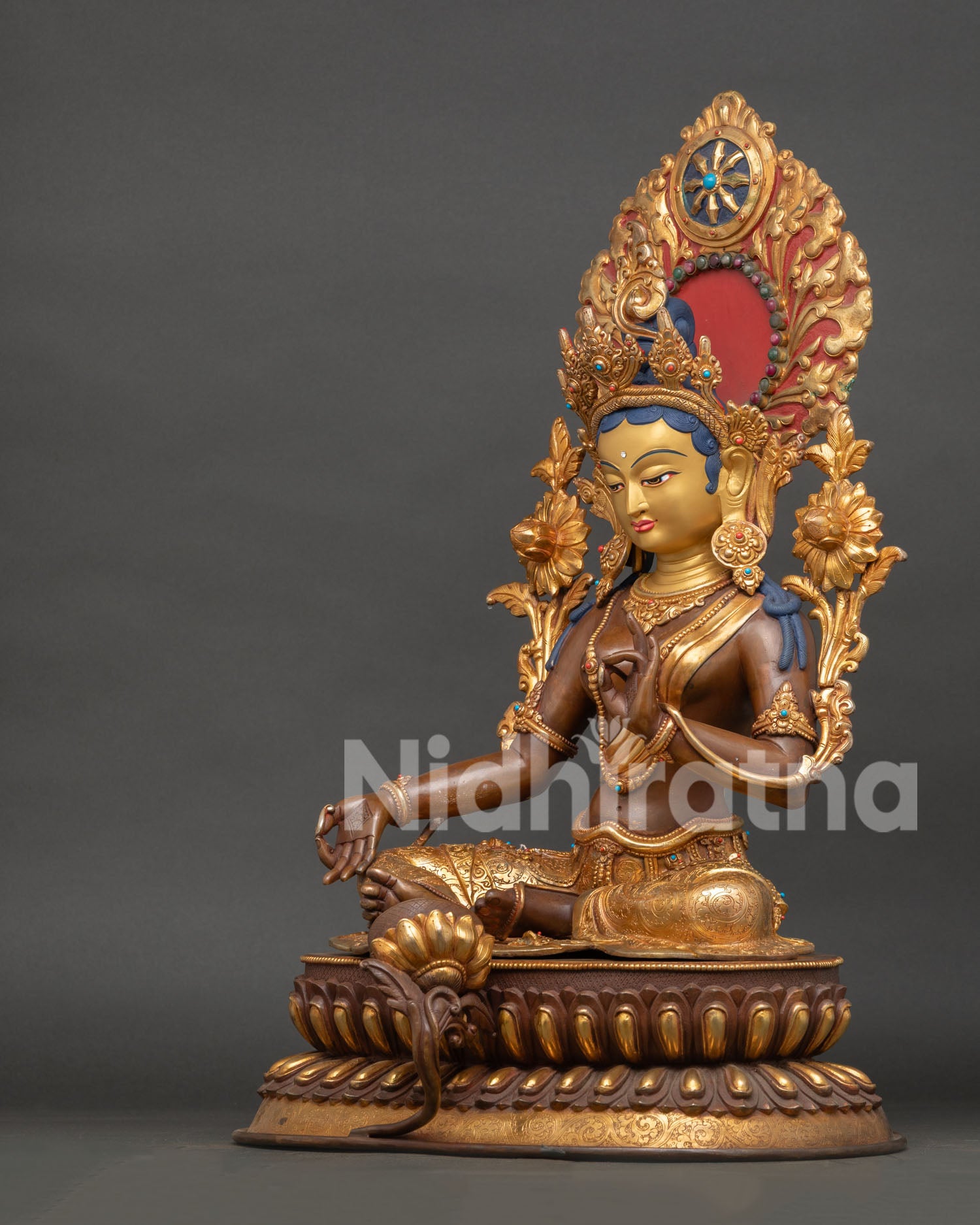 Green tara statue side view with intricate halo, crown and traditional nepalese craftsmanship