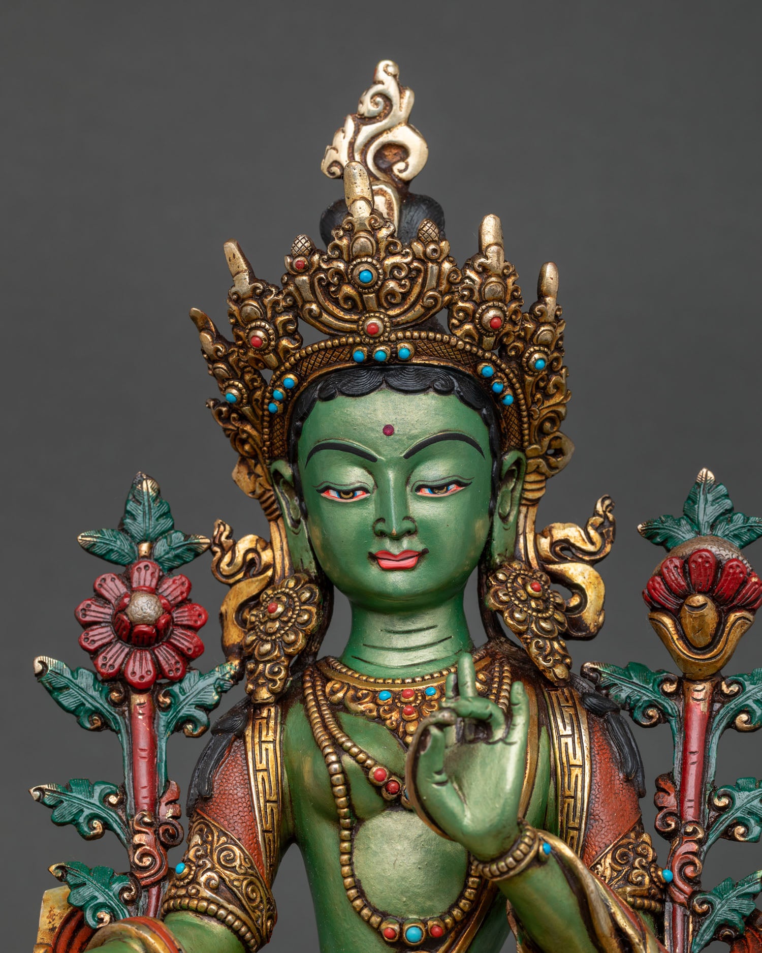 Green Tara statue upper body view showing gold crown and Varada Mudra hand