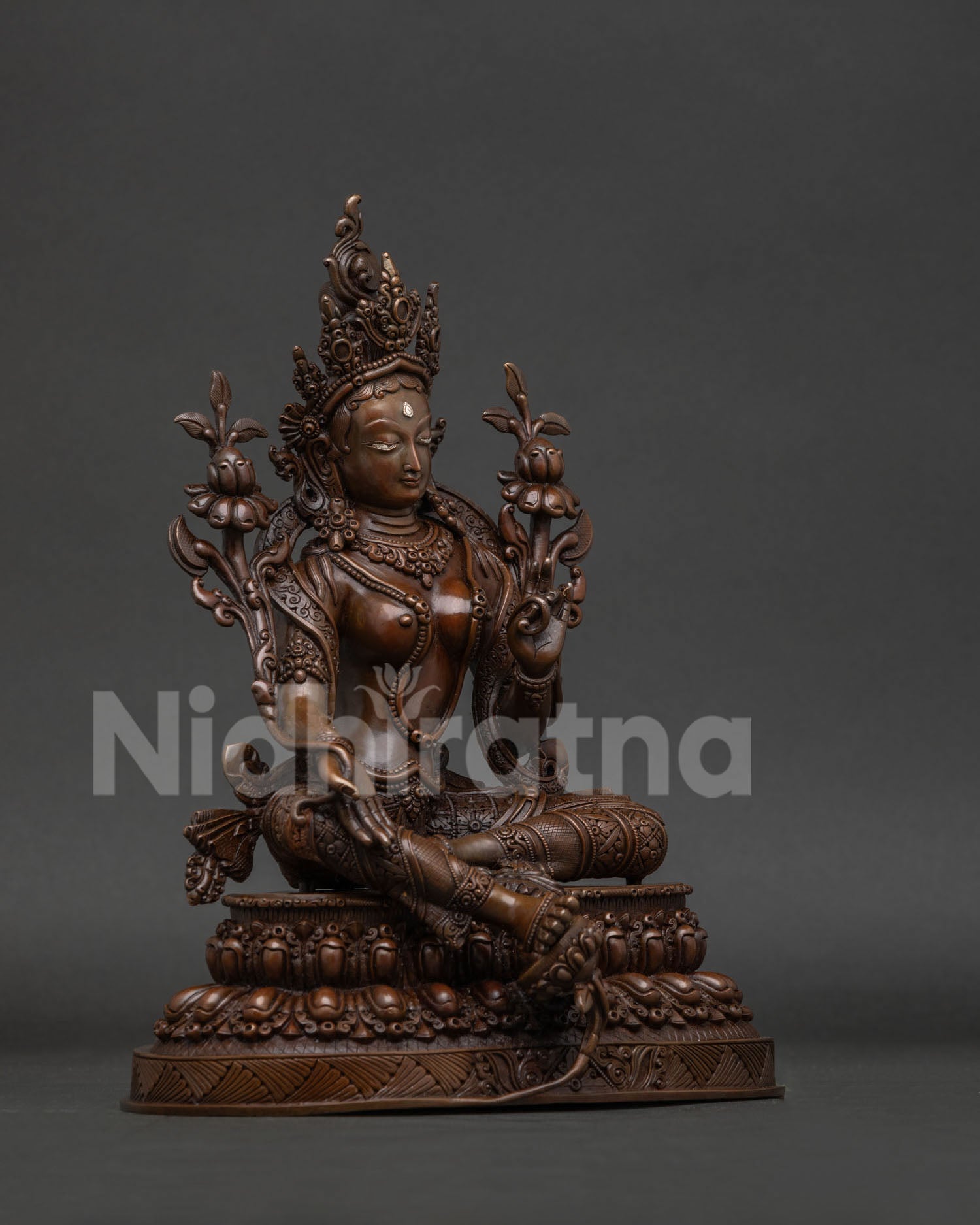 Green Tara statue with varada mudra and blooming utpala lotus.