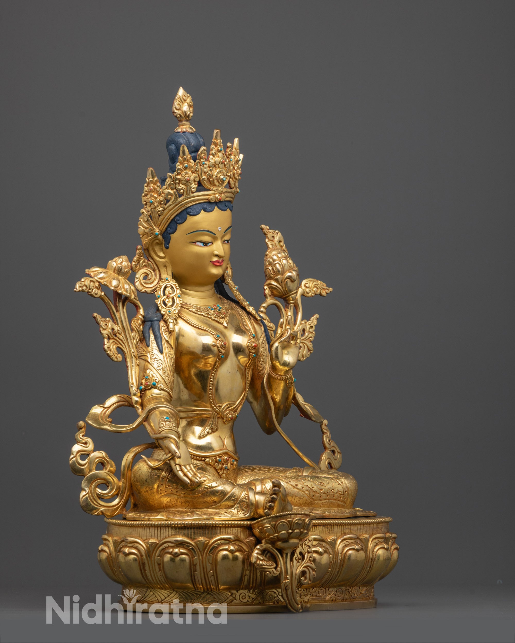 green tara statue side view highlighting fire-gilded body and handcrafted jewelry on copper base