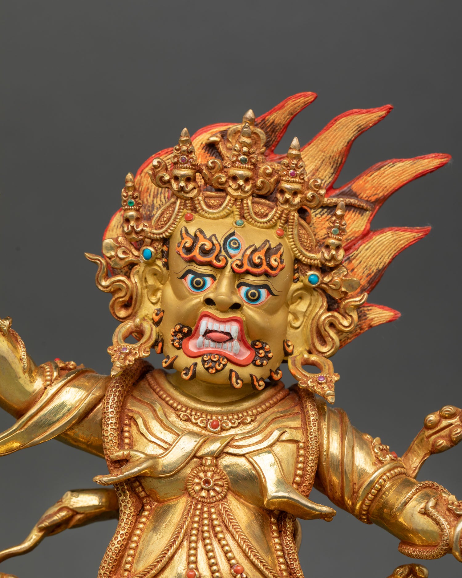 Guru Dragpo close up fierce expression with third eye gold gilded face copper statue adorned with semi precious stones Vajrayana deity.