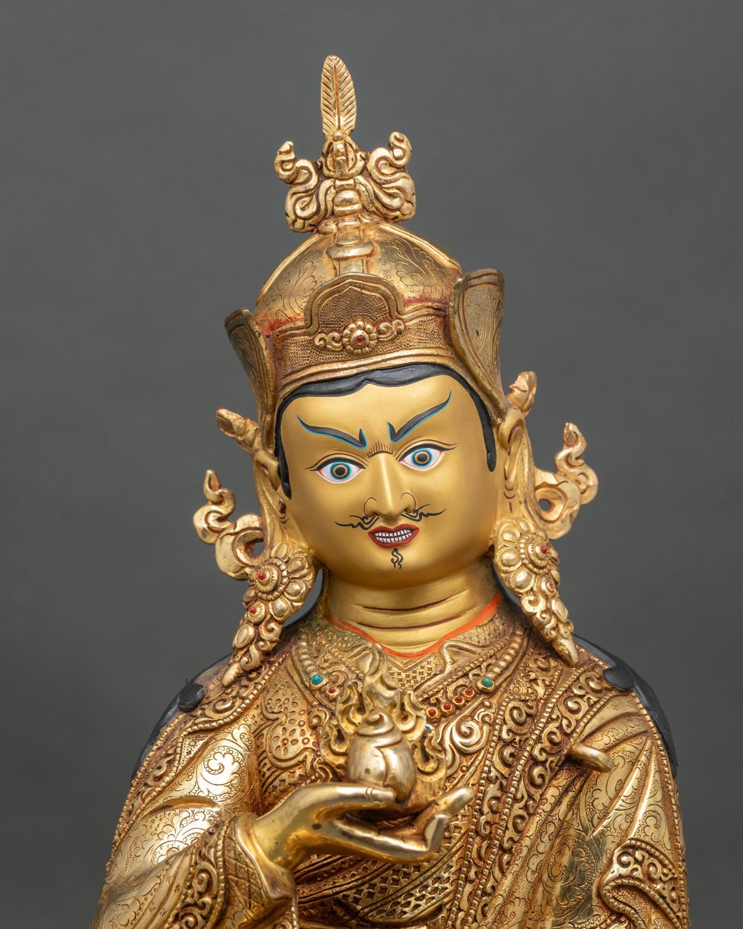 Close-up of Guru Norlha statue showing jewel banner and lotus throne details