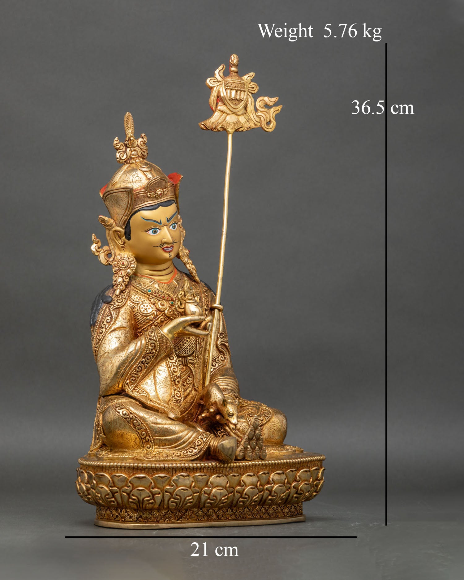 Right profile of Guru Norlha statue seated on lotus, holding wish-fulfilling jewel
