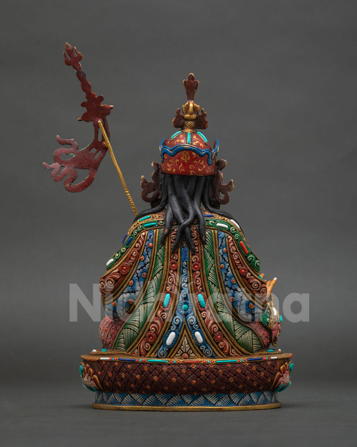 Guru padmasambhava statue with khatvanga staff colorful ornaments and traditional nepalese craftsmanship.