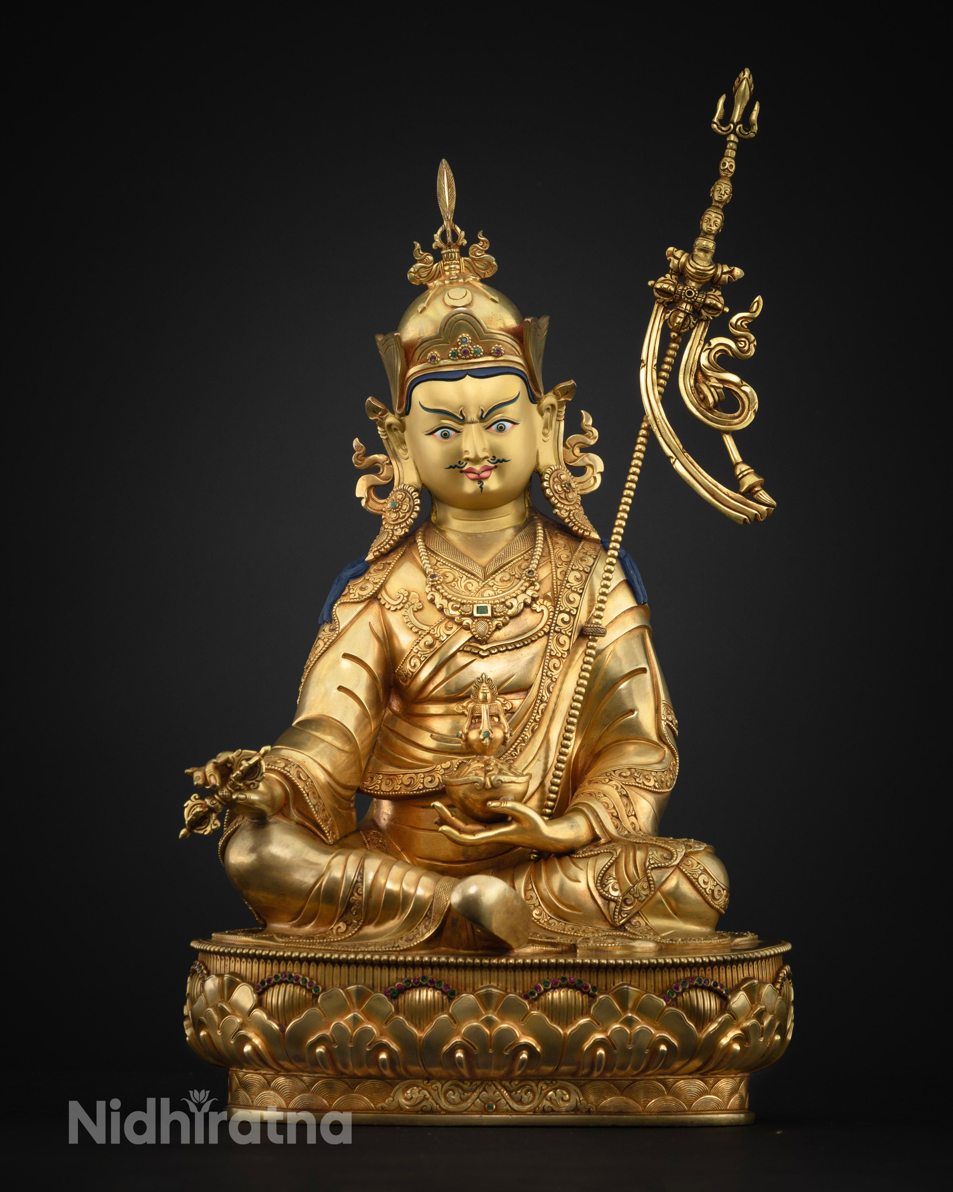 Guru Rinpoche Buddhist statue holding vajra and kapala with trident on shoulder