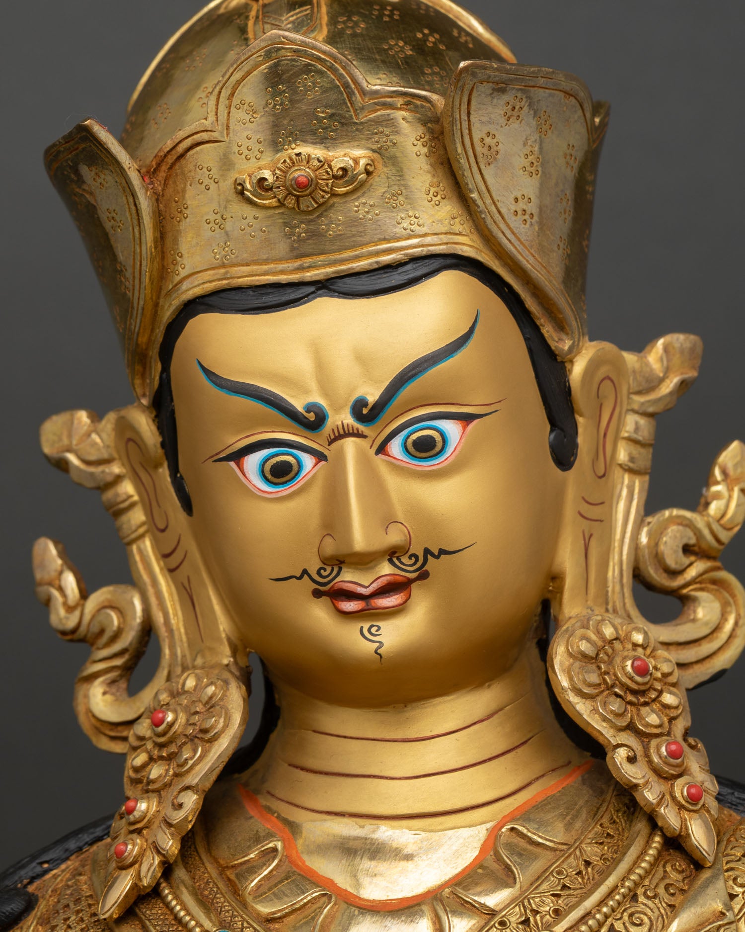 Guru Rinpoche face close up gold painted serene expression Padmasambhava statue