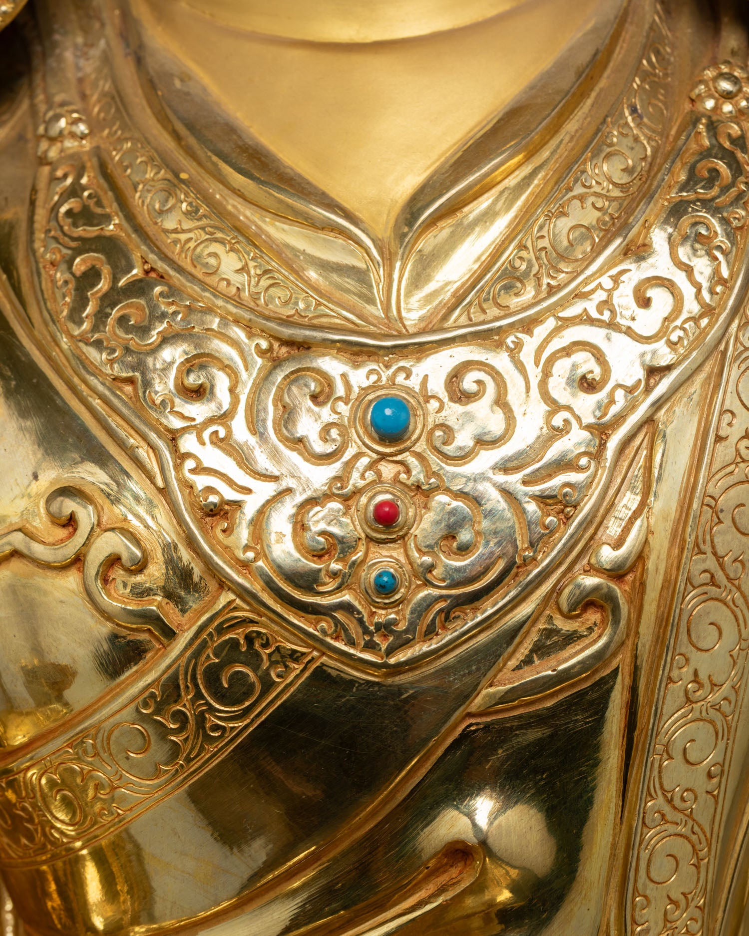 Guru Rinpoche robe ornament detail with turquoise and coral gemstones on handcrafted copper statue