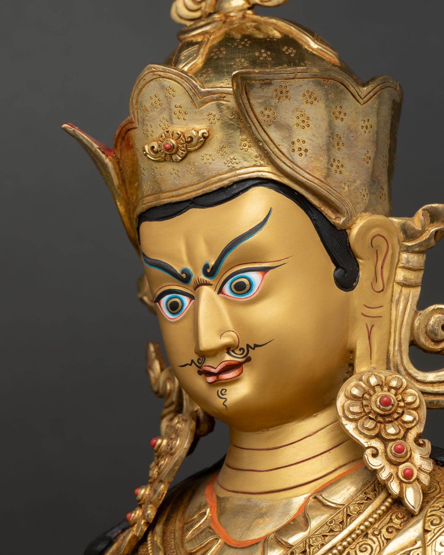 Guru Rinpoche side face close up gold painted expression ornate crown detail
