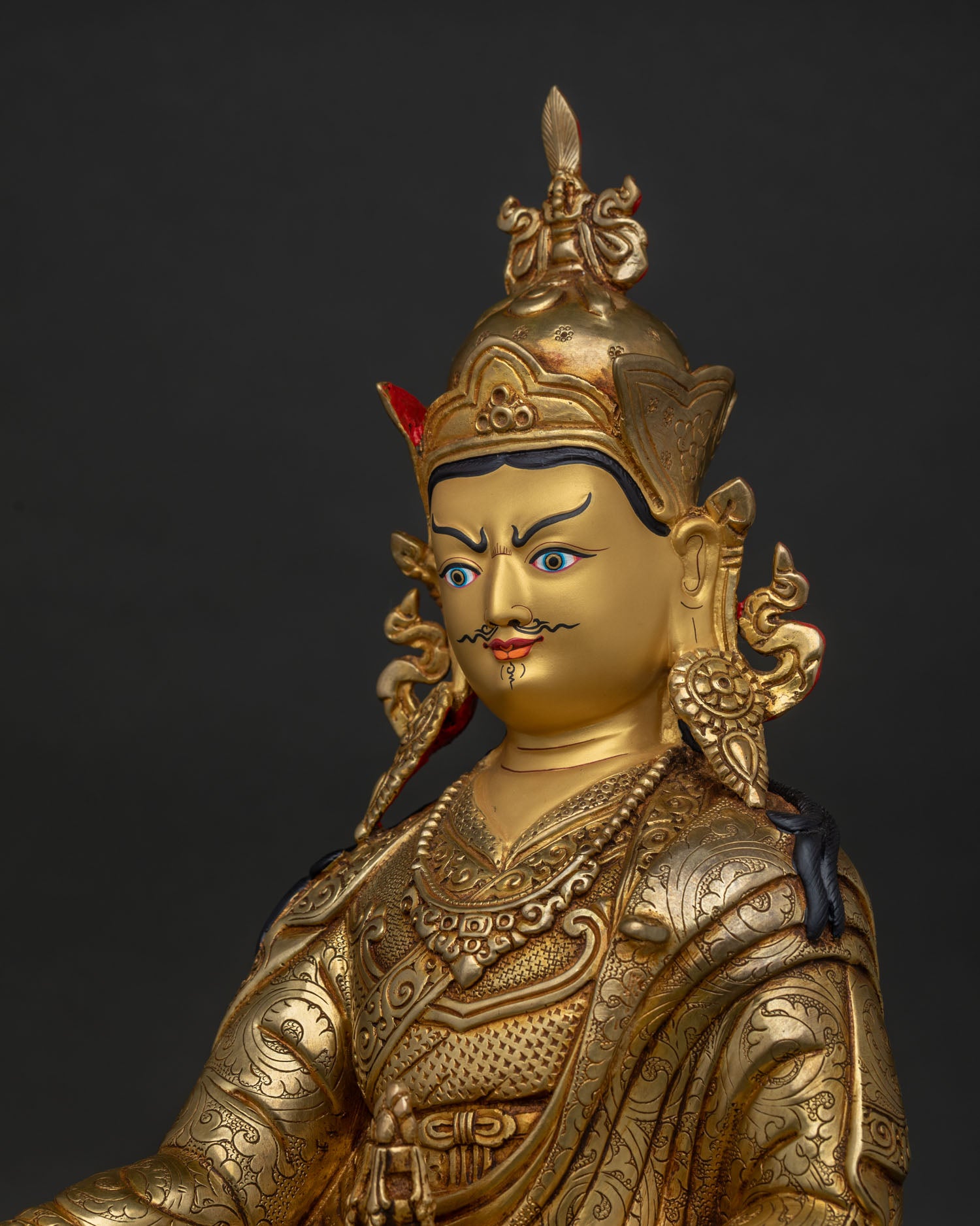 guru rinpoche statue gold painted face detailed side close up