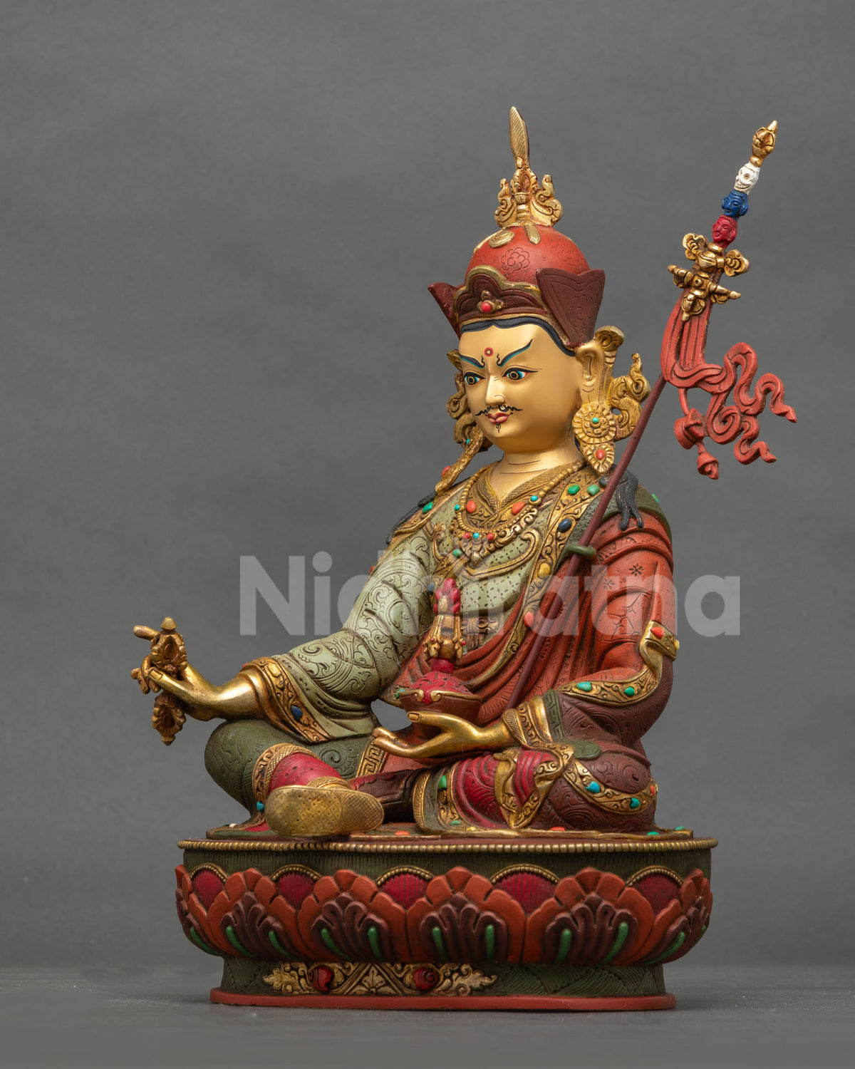 Guru Rinpoche Statue left side view khatvanga trident skulls flowing banner.