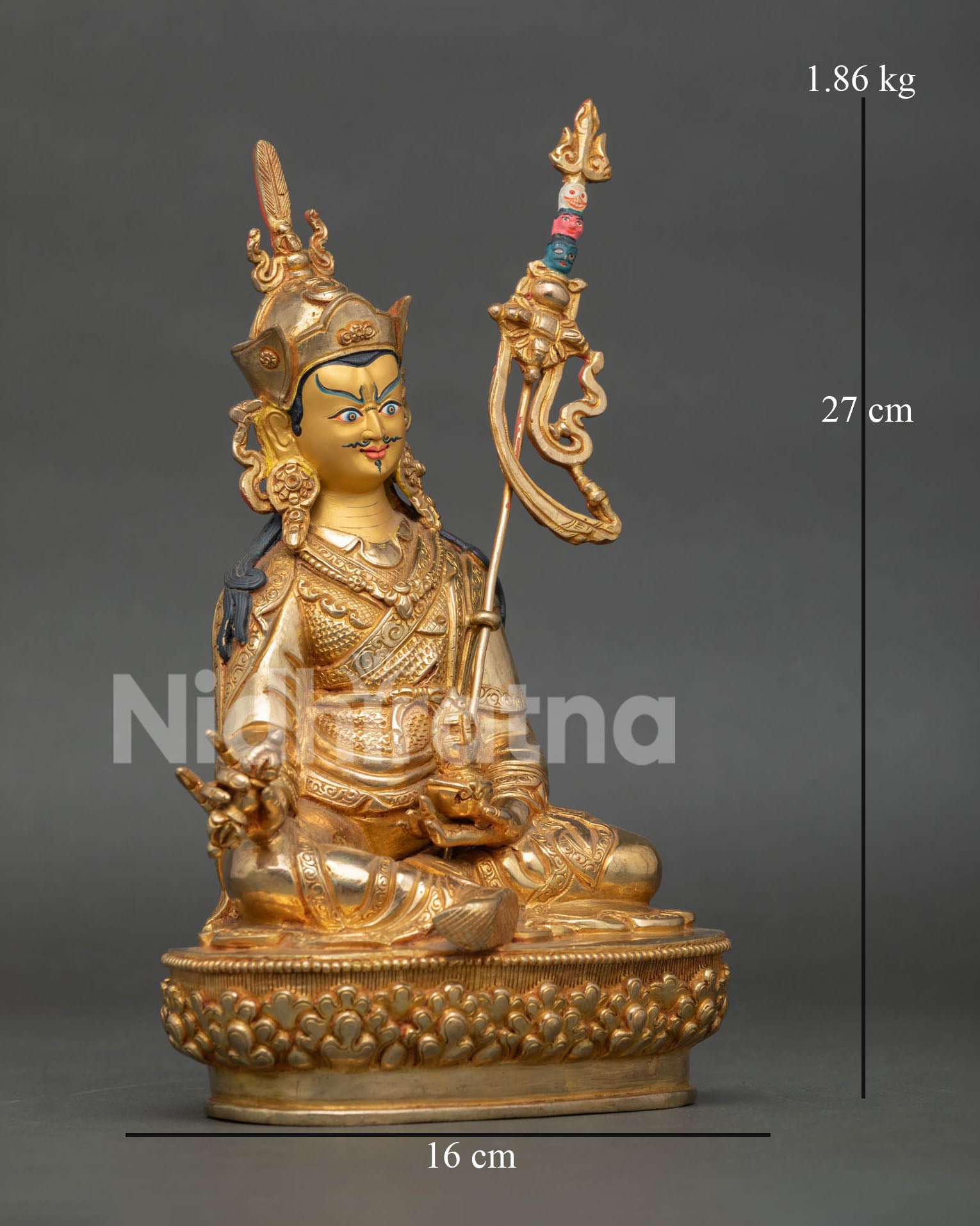 Guru Rinpoche statue on lotus pedestal holding vajra trident and skull cup with vase