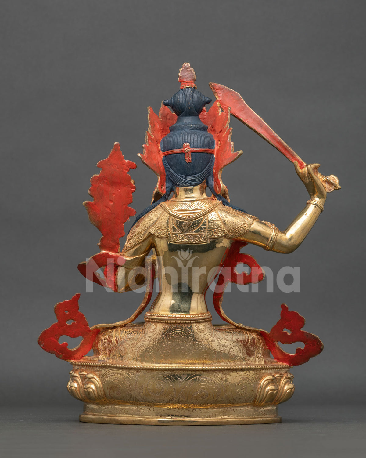 Hand carved Manjushri statue with floral garment and semi precious stones.