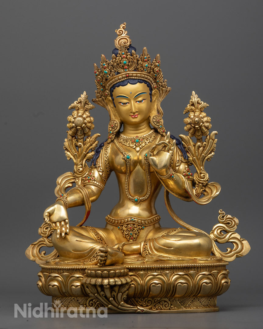 hand-carved Green Tara Statue made in Nepal, gilded in 24k gold and adorned with semi-precious stones, seated on a lotus throne.