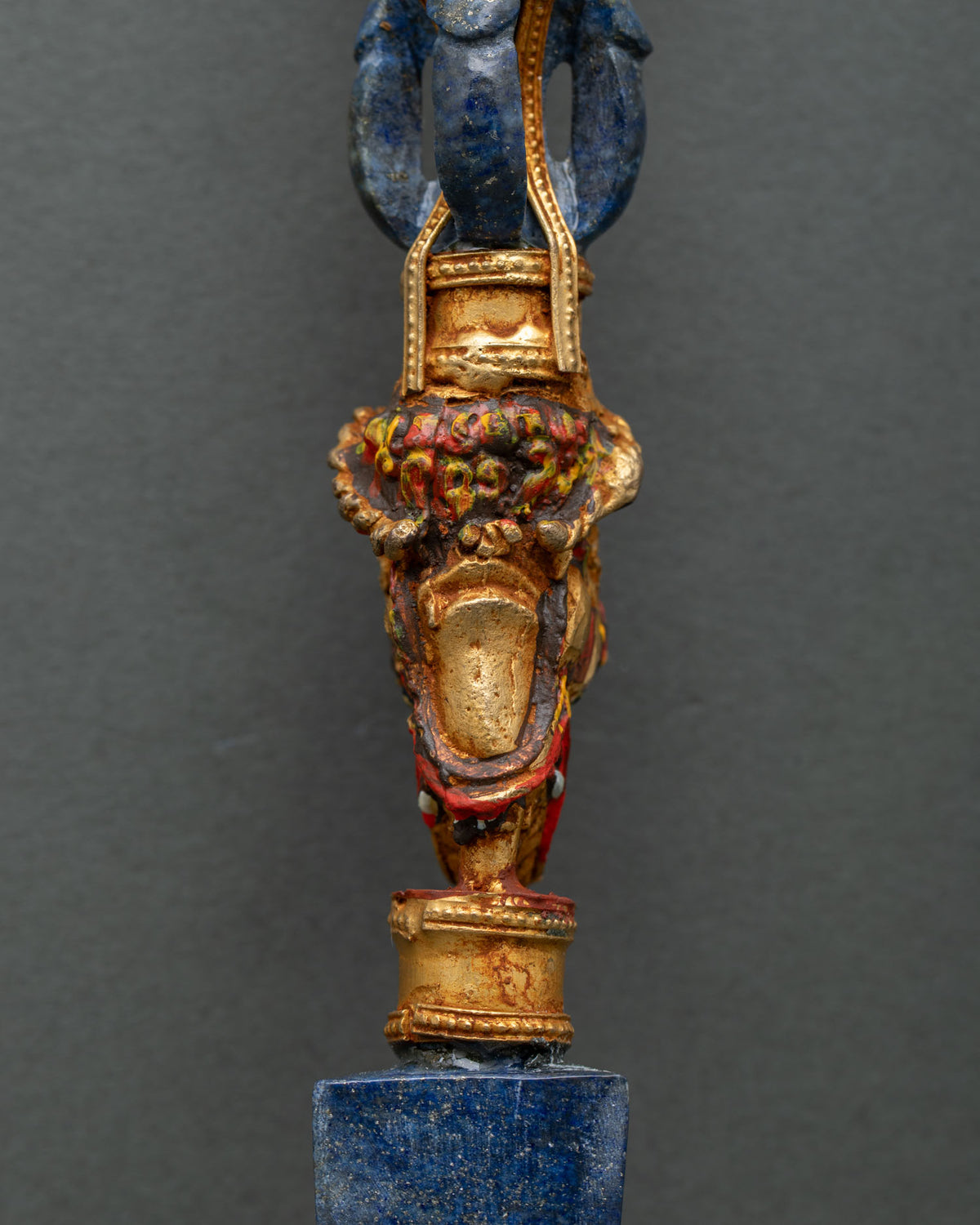 Hand-painted gold-gilded makara head below the lapis vajra shank of a Tibetan phurba ritual dagger