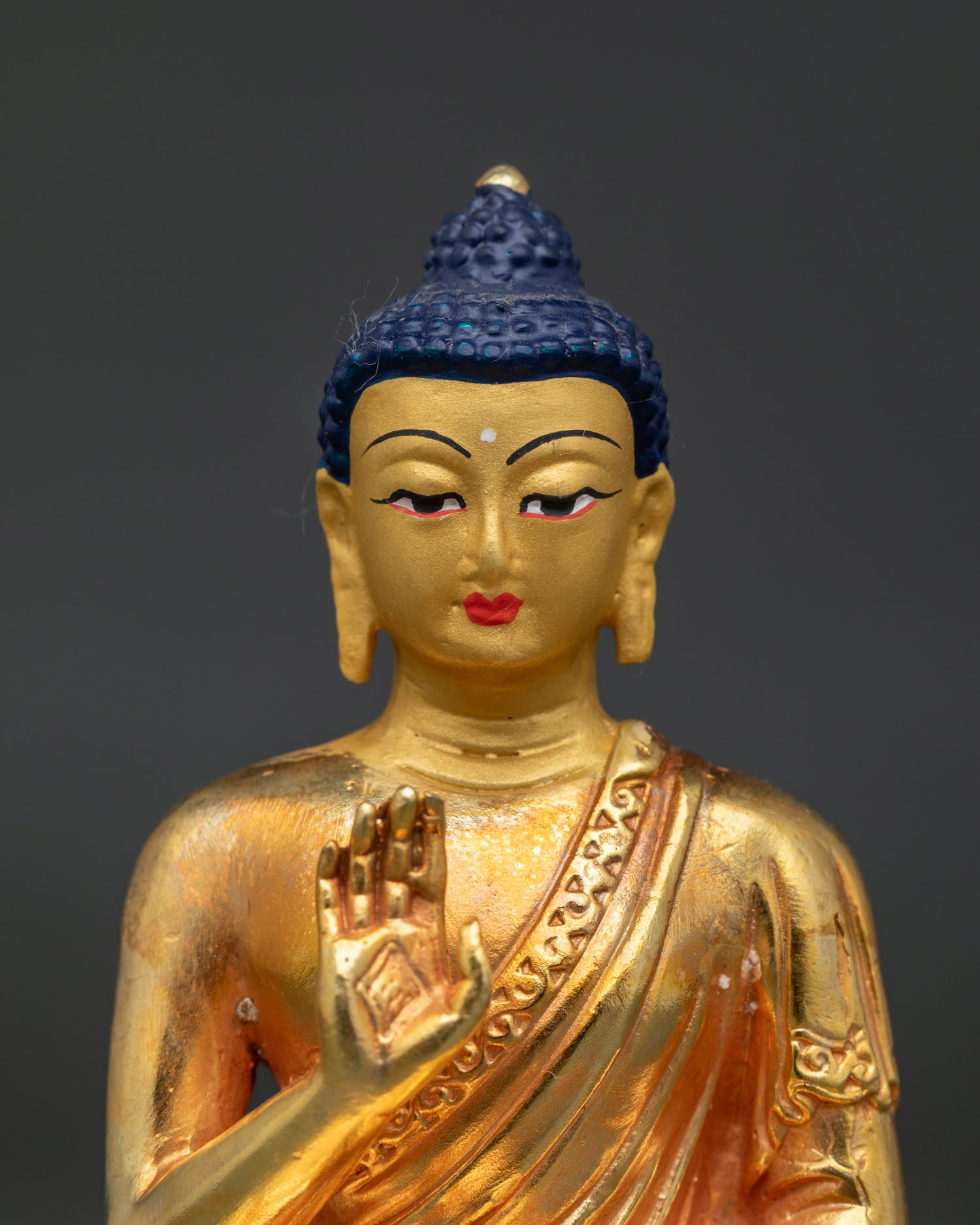 Handcrafted Amoghasiddhi Buddha Statue close-up showing gold-painted face and serene expression