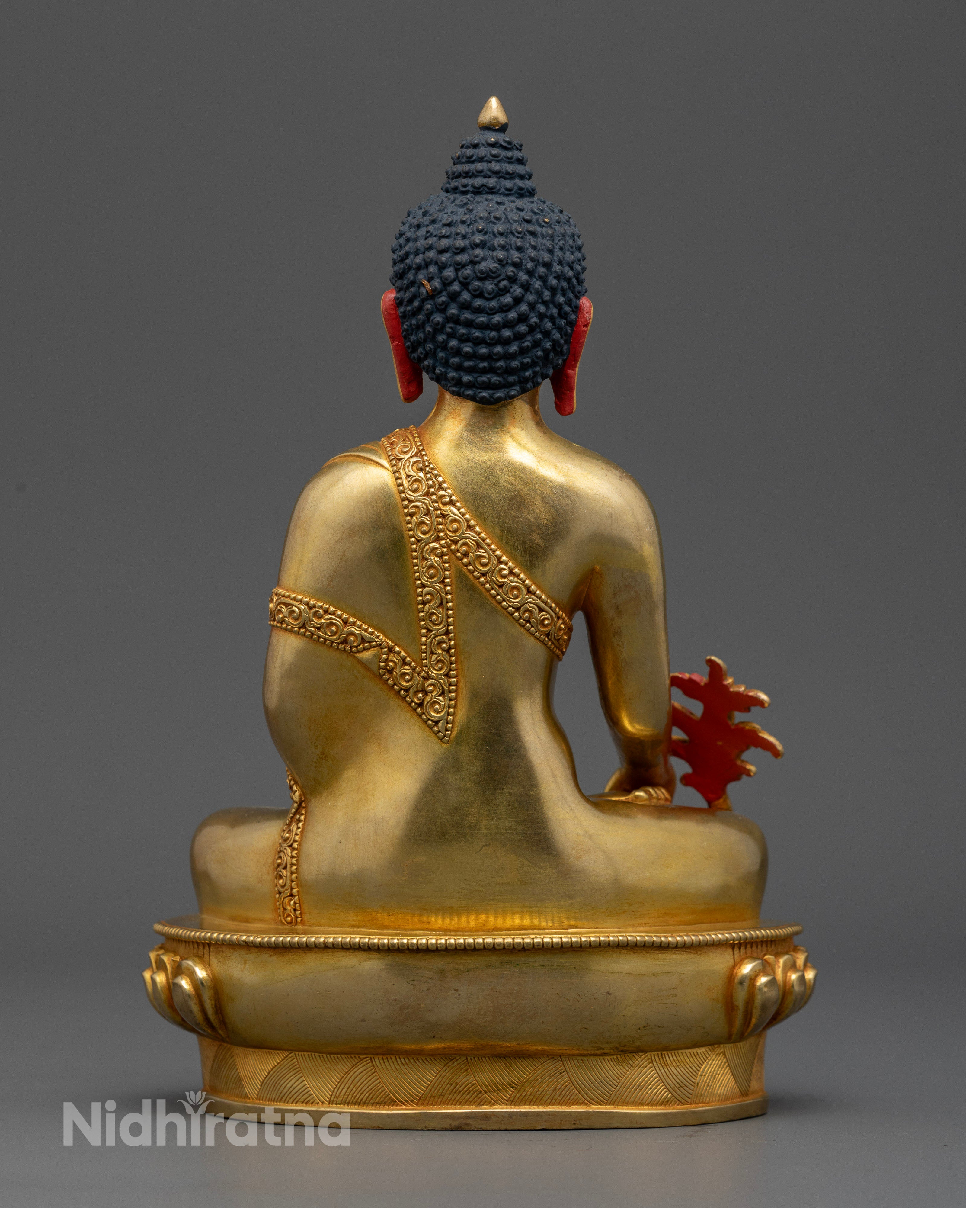 Handcrafted bhaisajyaguru statue seated on lotus pedestal with gold gilded details.